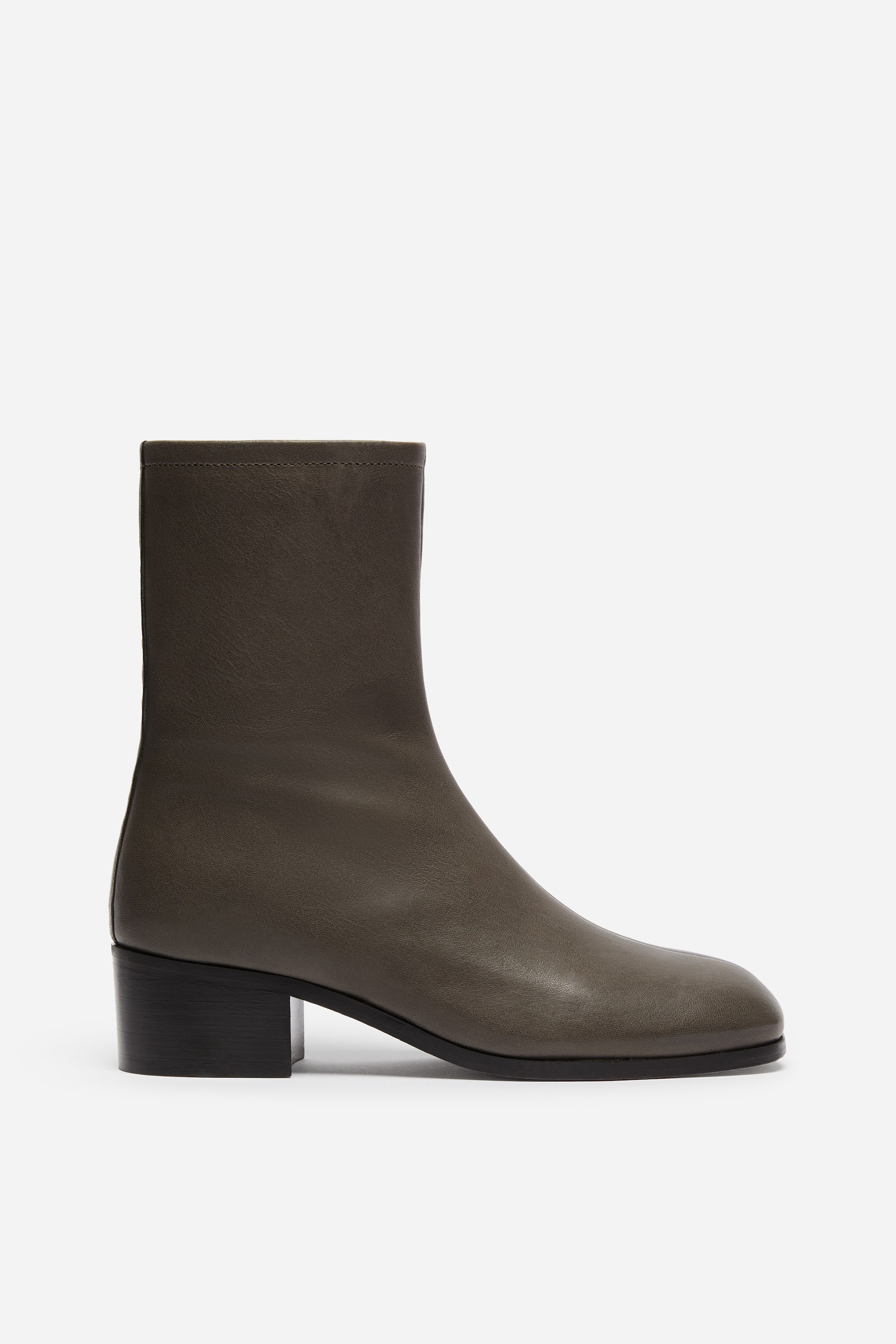Größeres Bild ansehen: Ein einzelner dunkelolivgrauer Leder-Stiefelette ist in Seitenansicht dargestellt und verfügt über einen enganliegenden Schaft sowie eine abgerundete Spitze. Der Stiefel ist mit einem niedrigen schwarzen Blockabsatz und einer dünnen schwarzen Sohle gestaltet, was die minimalistische Silhouette betont.