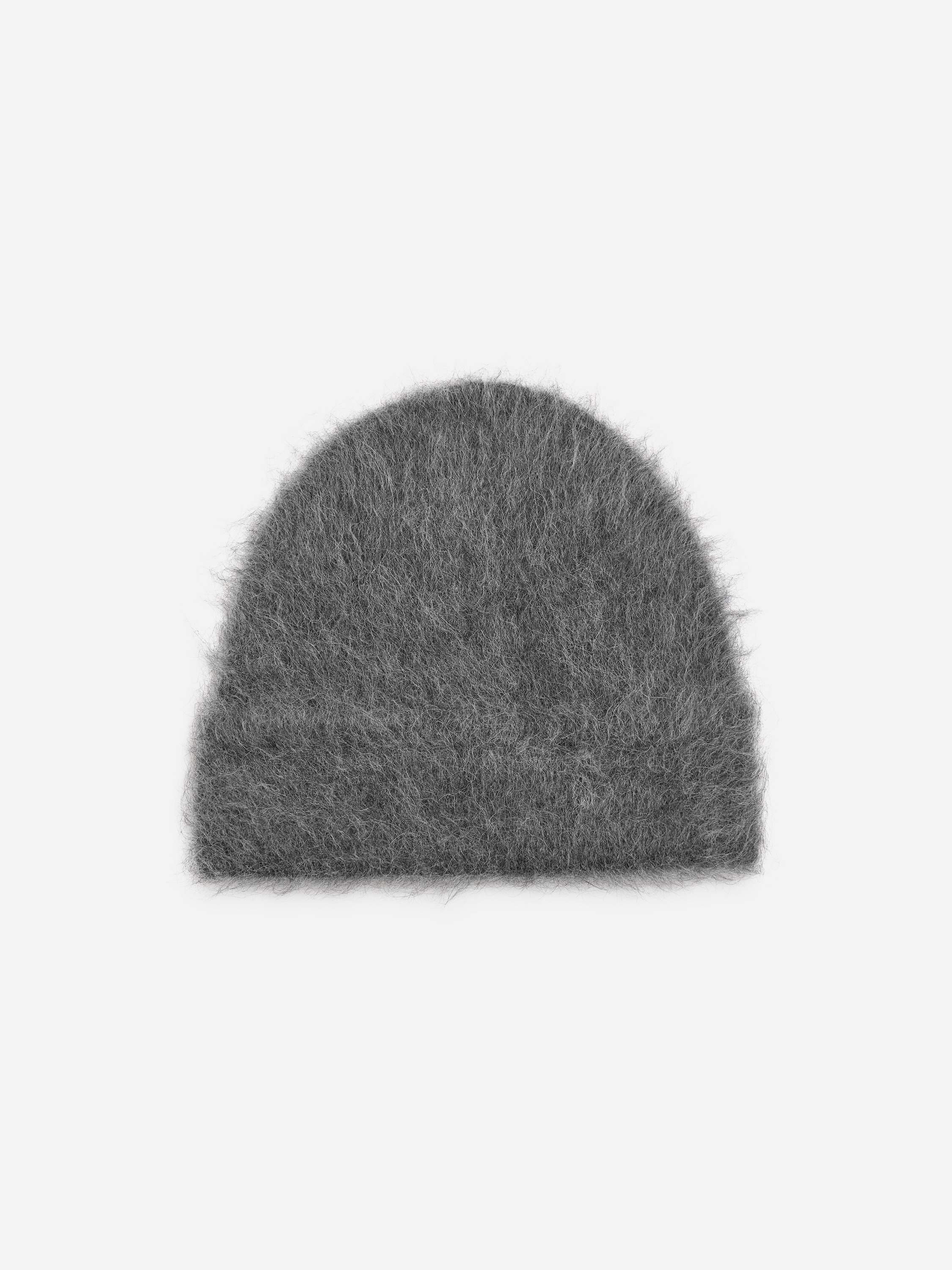 A dark grey, fluffy beanie with a brushed knitted texture is being worn by the model. The beanie is styled with a high-collared black puffer jacket.