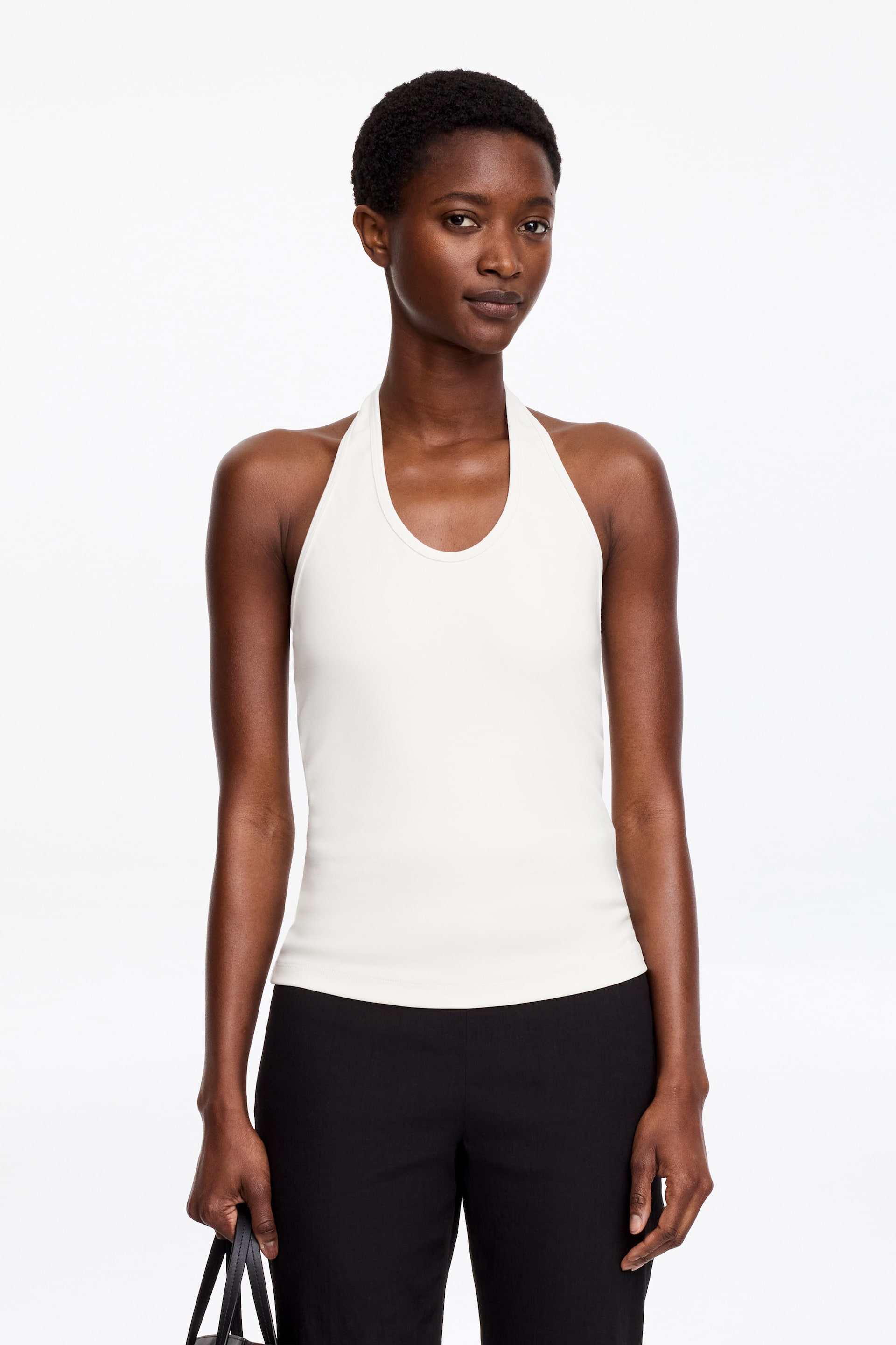Visualizza l'immagine ingrandita: Un top bianco all'americana, realizzato in jersey di cotone elasticizzato, è indossato dalla modella, mettendo in risalto la sua vestibilità aderente.