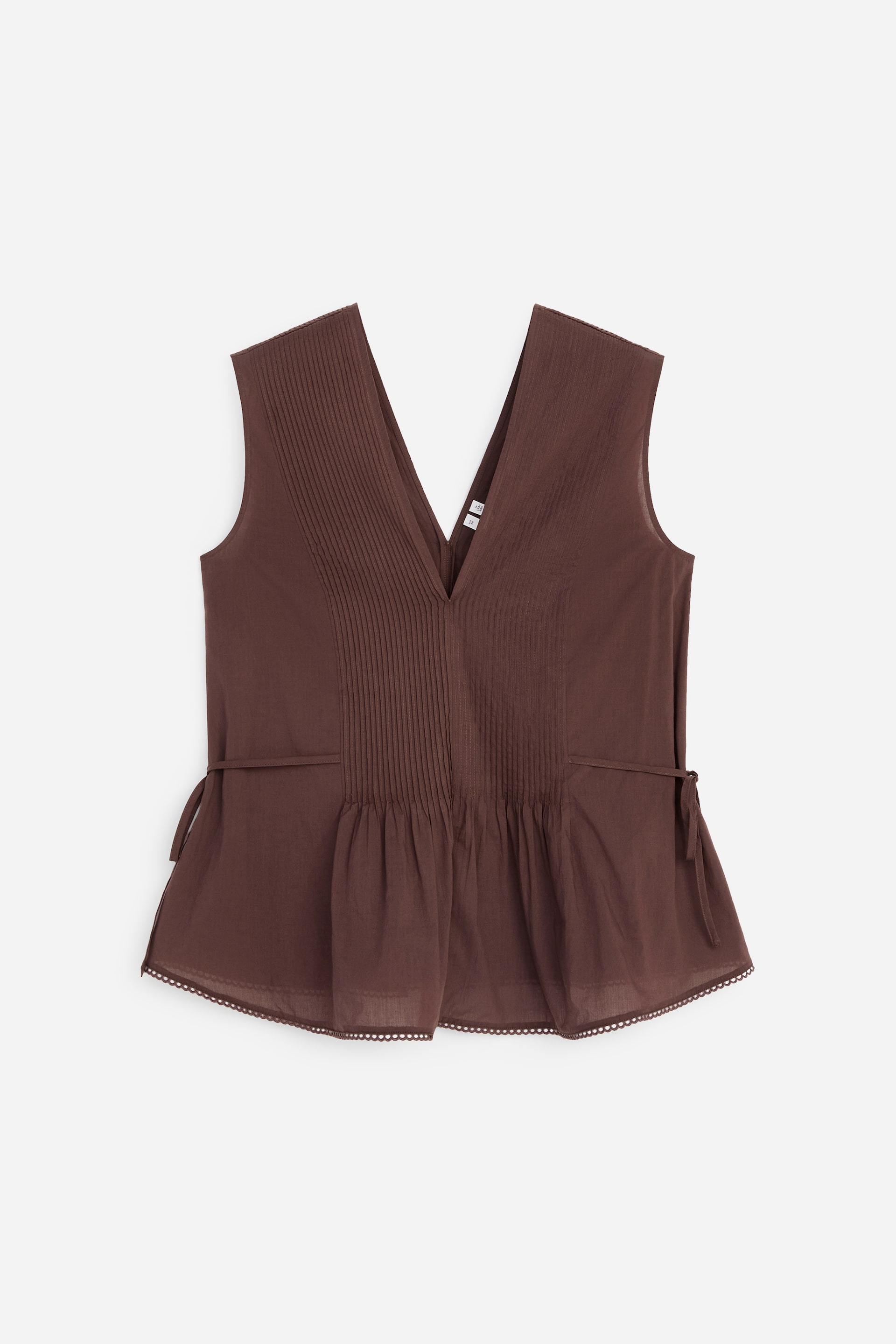 Visualizza immagine più grande: Una blusa in voile di cotone marrone è vista frontalmente, con dettagli a pieghe sul petto, coulisse laterali che creano arricciature in vita e un bordo in pizzo lungo l'orlo.