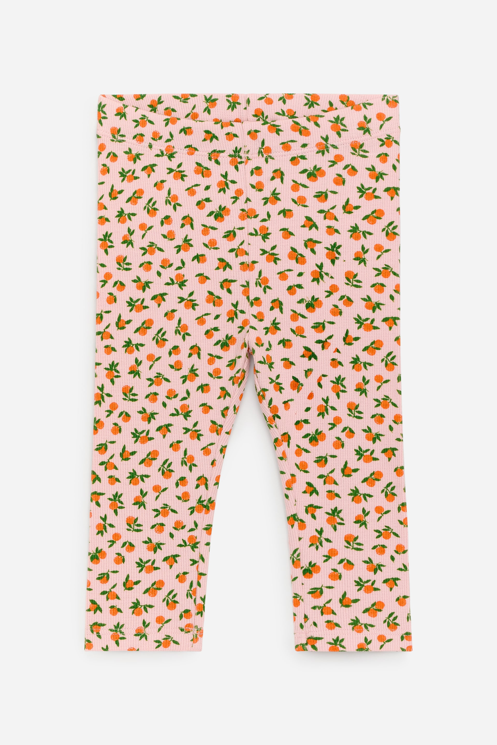 Visa större bild: Ribbstickade leggings i mjukt bomullsjerseytyg med justerbara resår i midjan visas framifrån, i en ljusrosa färg med ett heltäckande mönster av små orange frukter och gröna blad.