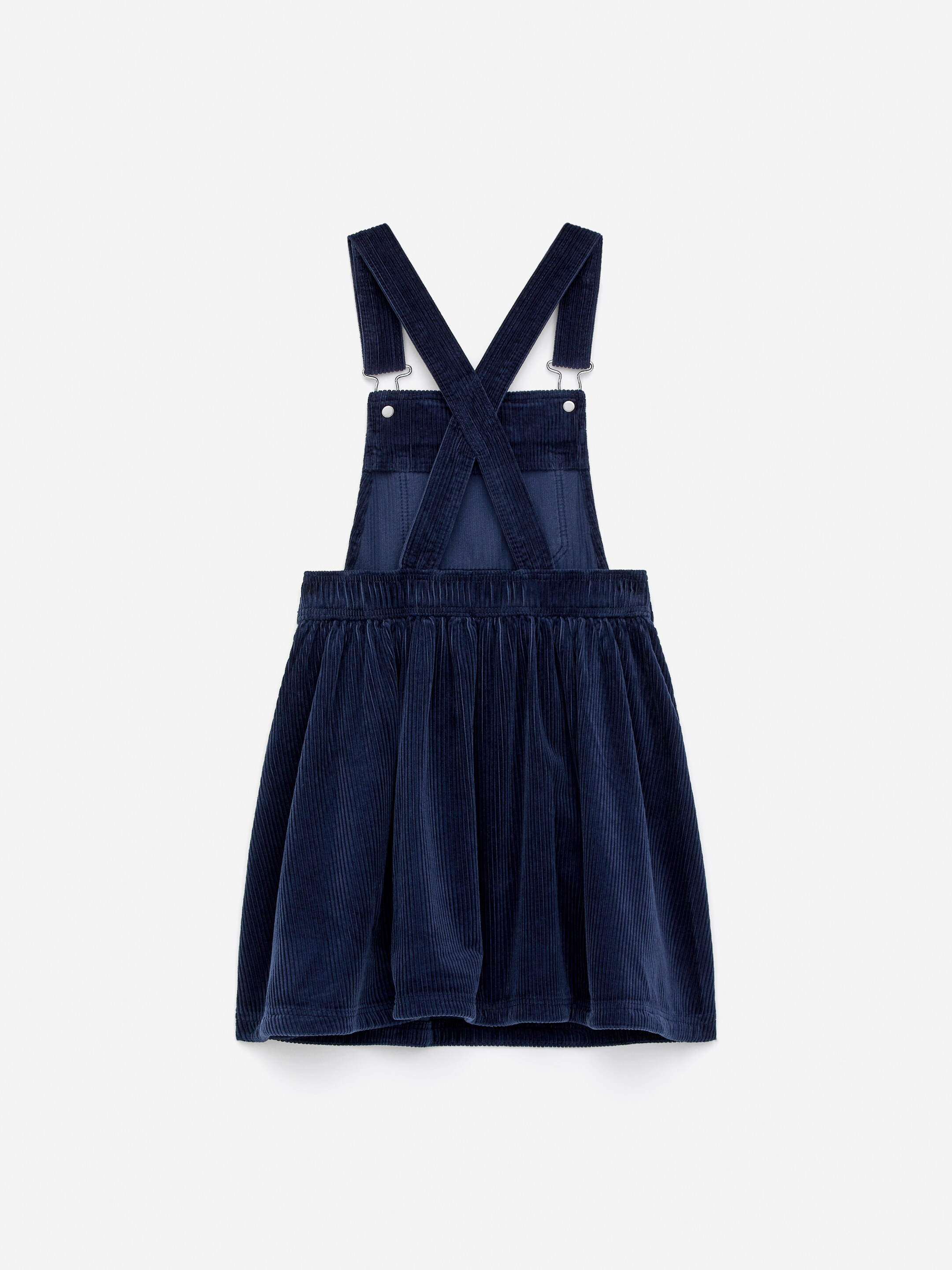 Vis større bilde: En marineblå selekjole i dongeri-stil, laget av bomullsfløyel, har justerbare skulderstropper som krysser på ryggen med metallspenner, og en elastisk midje over et rynket A-linje skjørt.