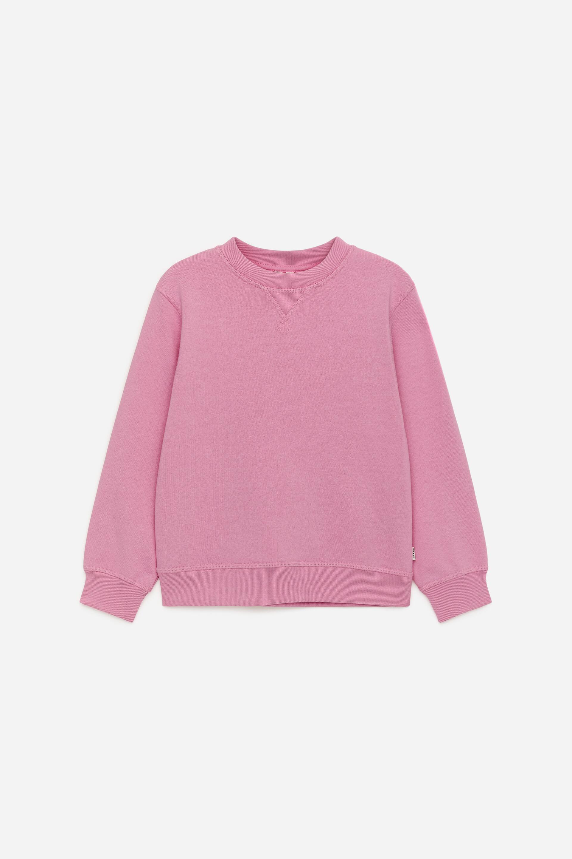 Agrandir l'image: Un sweat-shirt rose à col rond est présenté de face, avec des manches longues munies de poignets côtelés et un ourlet côtelé. Un détail en V est visible sous le col rond.