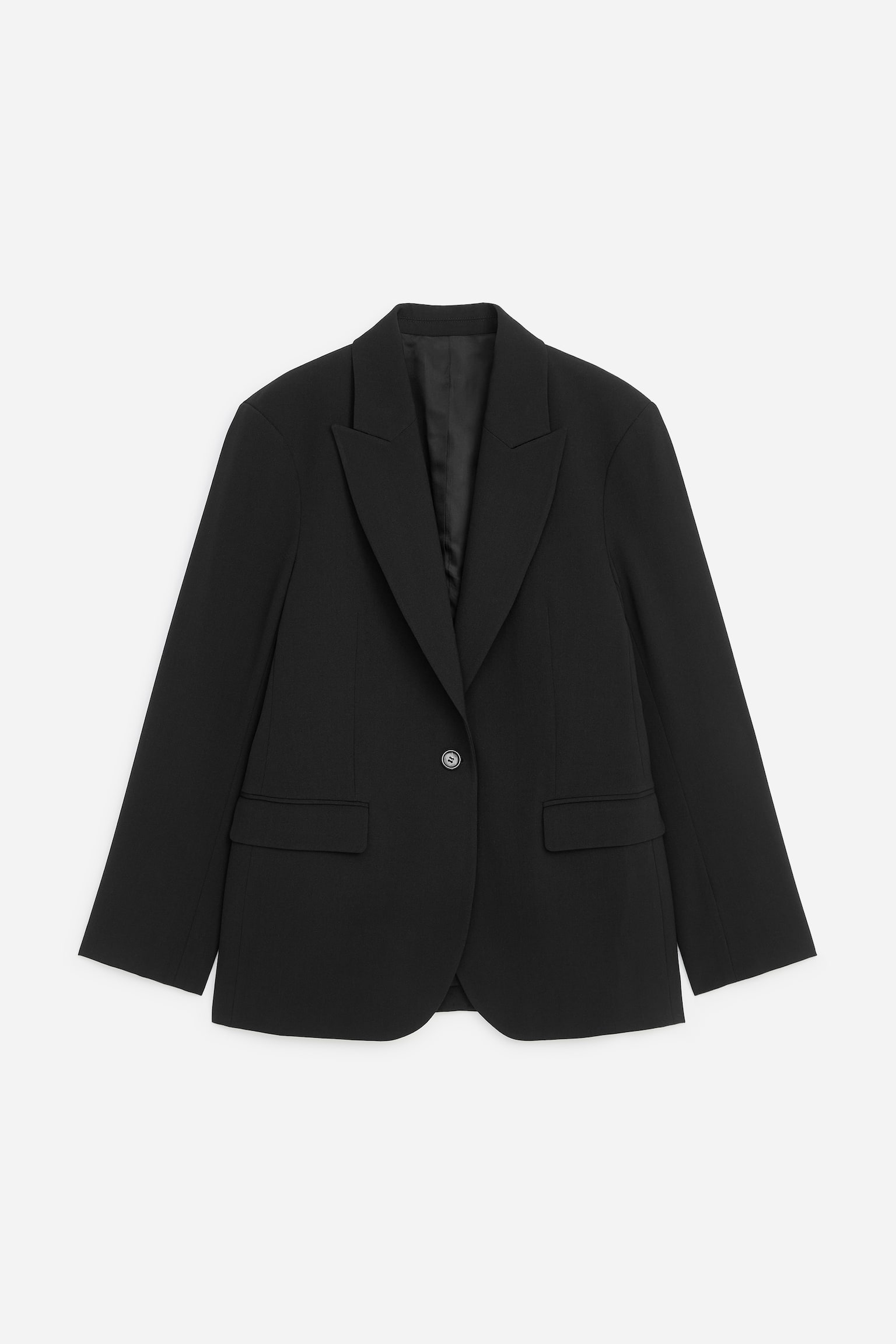 En svart kavaj med enkelknÃ¤ppning visas framifrÃ¥n, med en avslappnad men skrÃ¤ddad struktur, skarpa peak lapels och en enkelknÃ¤ppning framtill. Kavajen har markerade axlar och tvÃ¥ fickor med lock framtill fÃ¶r en ren, klassisk silhuett.
