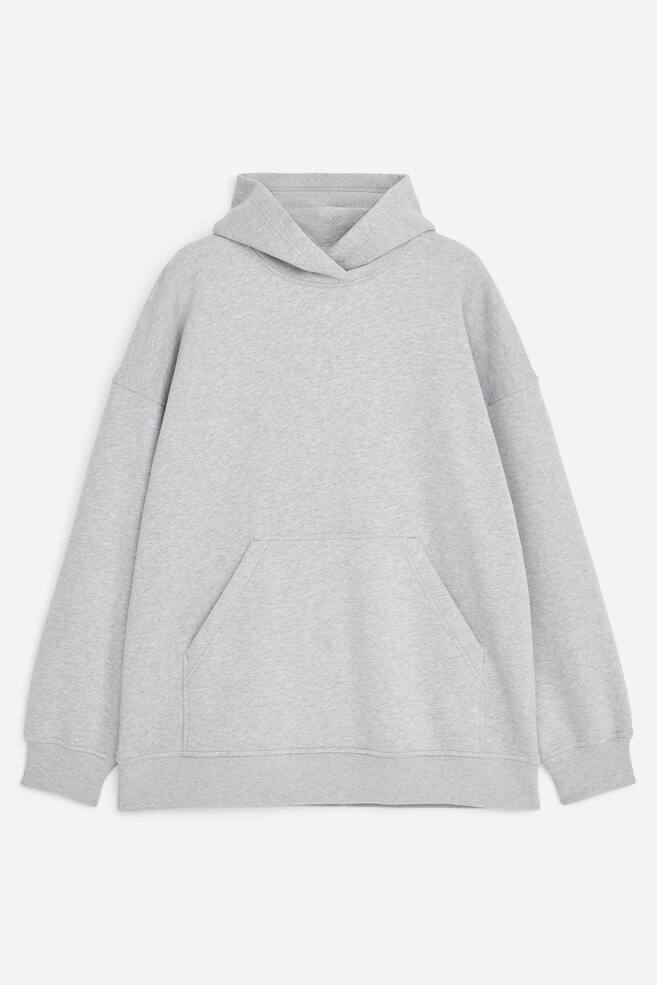 Un hoodie chinÃ© gris clair est prÃ©sentÃ© de face, avec une coupe dÃ©contractÃ©e, des Ã©paules tombantes, une capuche croisÃ©e sans cordons de serrage, une poche kangourou sur le devant et des finitions cÃ´telÃ©es aux poignets et Ã  lâourlet. - 1