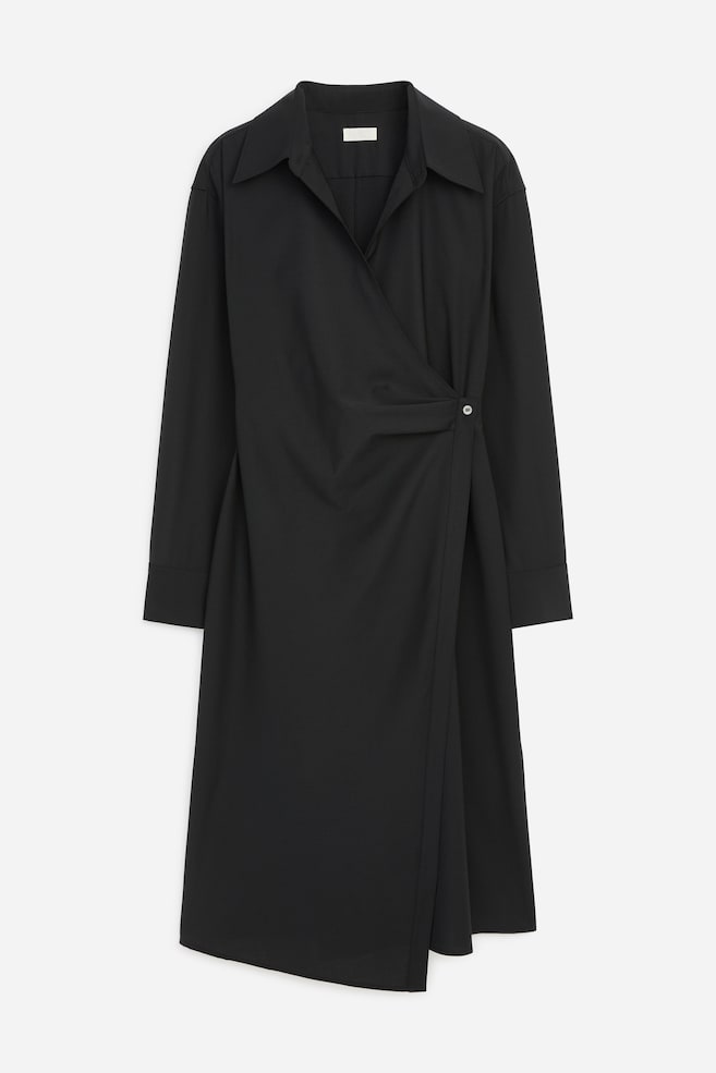 Ein schwarzes Wickel-Hemdkleid in Midilänge ist von vorne zu sehen und verfügt über einen spitzen Kragen, einen V-Ausschnitt sowie lange Ãrmel mit breiten Manschetten. Die vordere Partie fällt über den Oberkörper und wird an der Taille mit einem einzelnen Knopfverschluss geschlossen. - 1