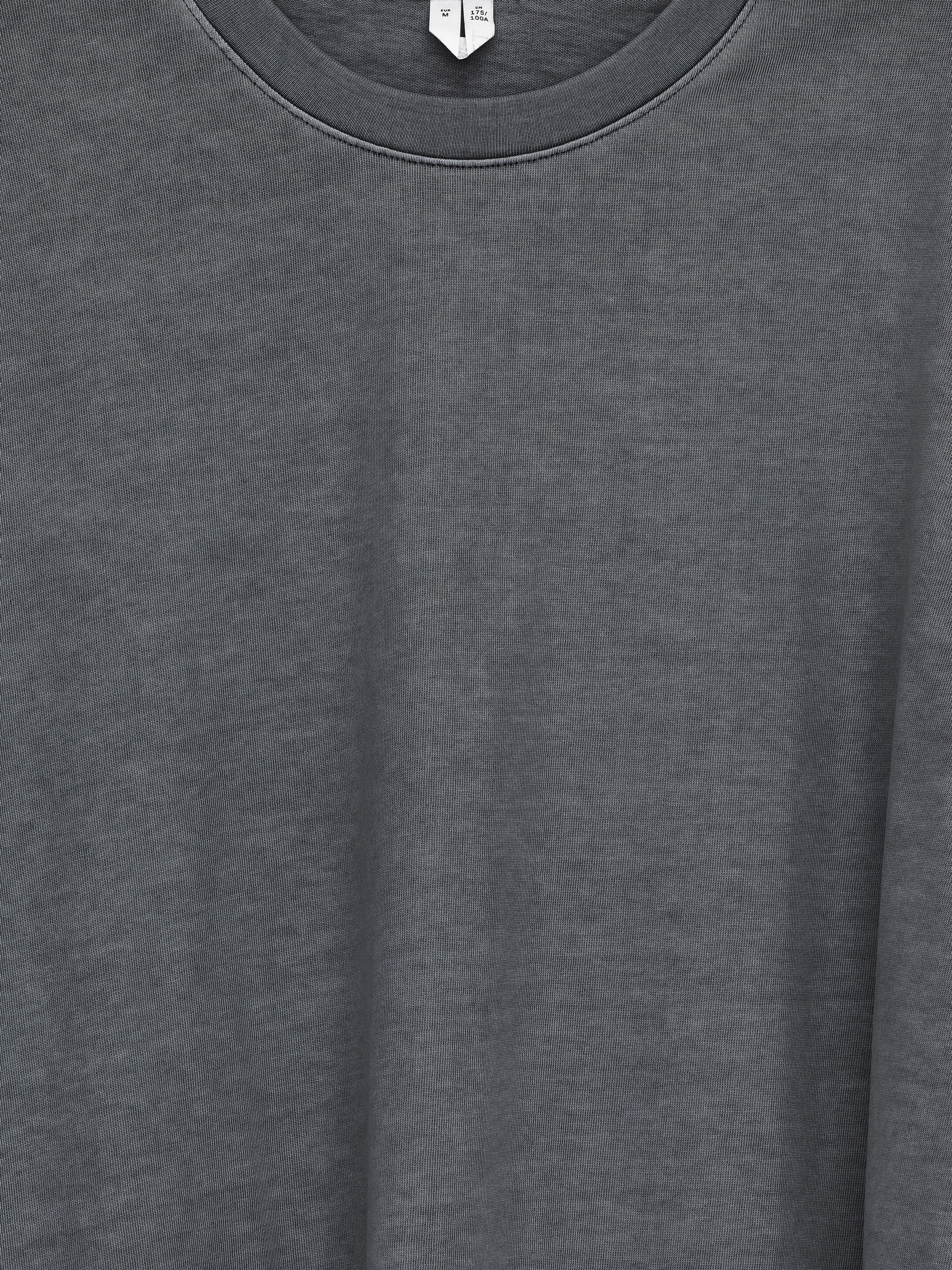 View larger image: A dark grey long-sleeved T-shirt is being displayed, featuring a classic crew-neck. Its cotton fabric is showing a washed texture, and a white size tag is visible at the back of the neck.