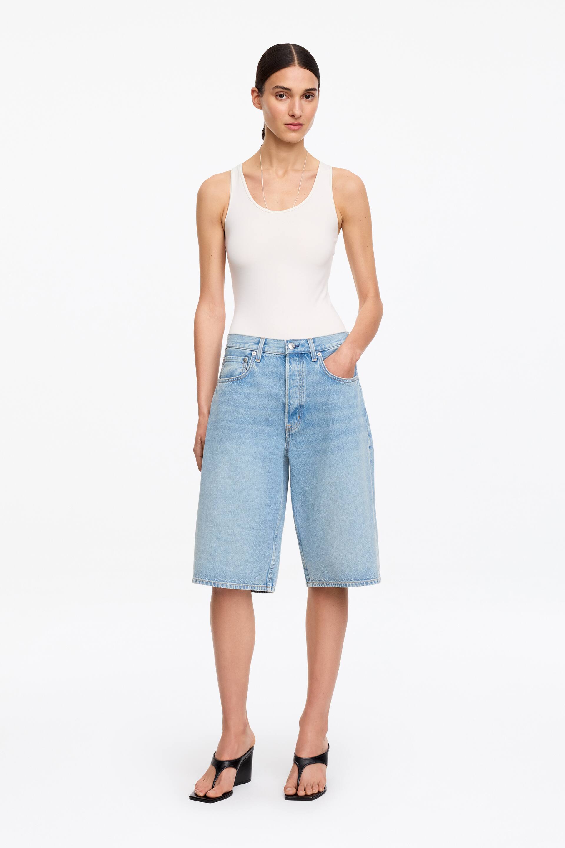 Grösseres Bild ansehen: Hellblaue Denim-Culottes sind frontal abgebildet und zeigen einen weiten, lockeren Schnitt, der bis zur Mitte der Wade reicht. Sie verfügen über eine hohe Taille und einen sichtbaren Knopfverschluss.