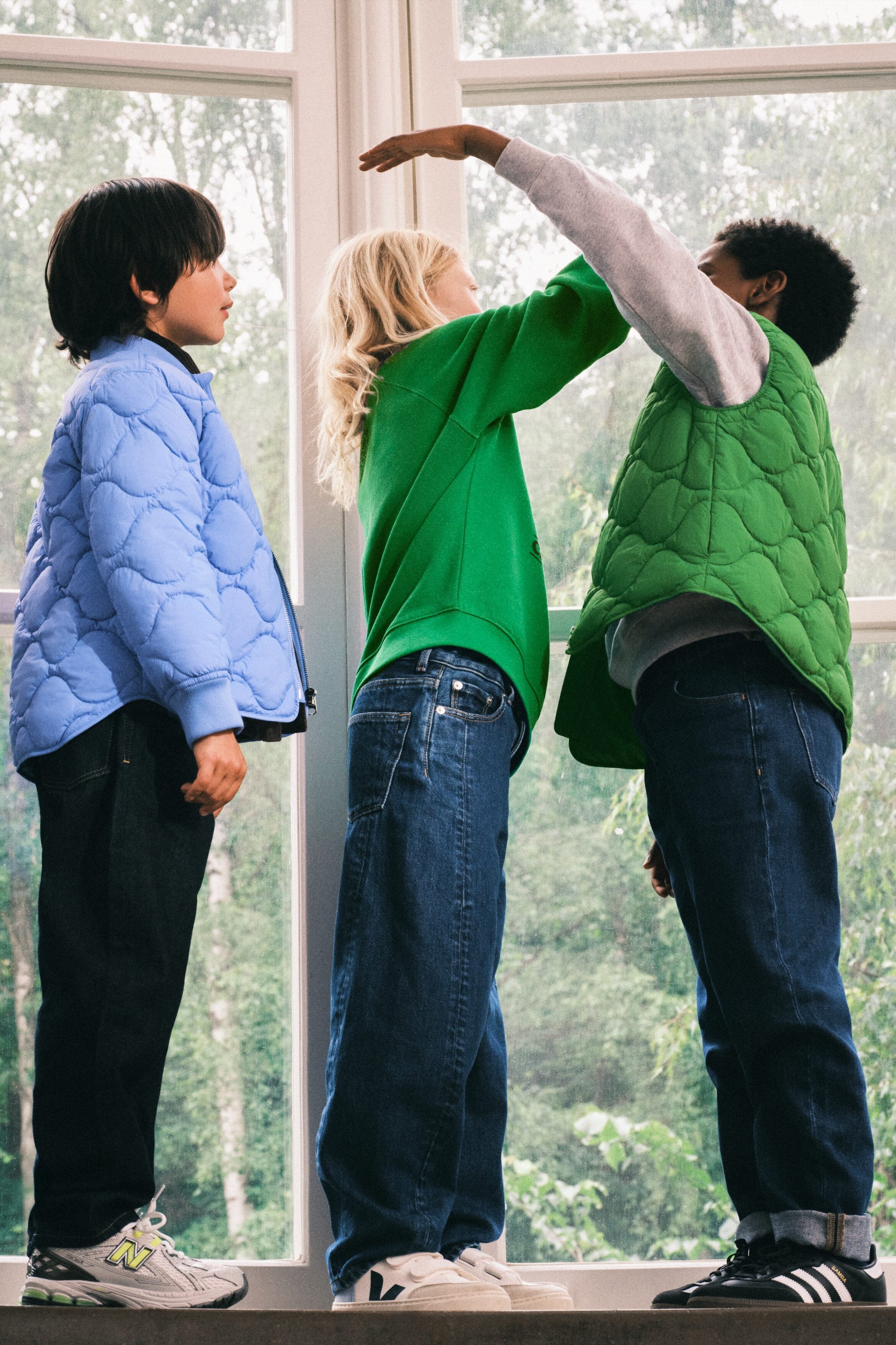 Größeres Bild anzeigen: Eine blaue Steppjacke wird getragen, aus einer seitlich-vorderen Perspektive gesehen. Sie verfügt über ein voluminöses, organisch gequiltetes Muster am gesamten Rumpf und an den langen Ärmeln. Unter dem Halsausschnitt ist ein schwarzer Stehkragen sichtbar.