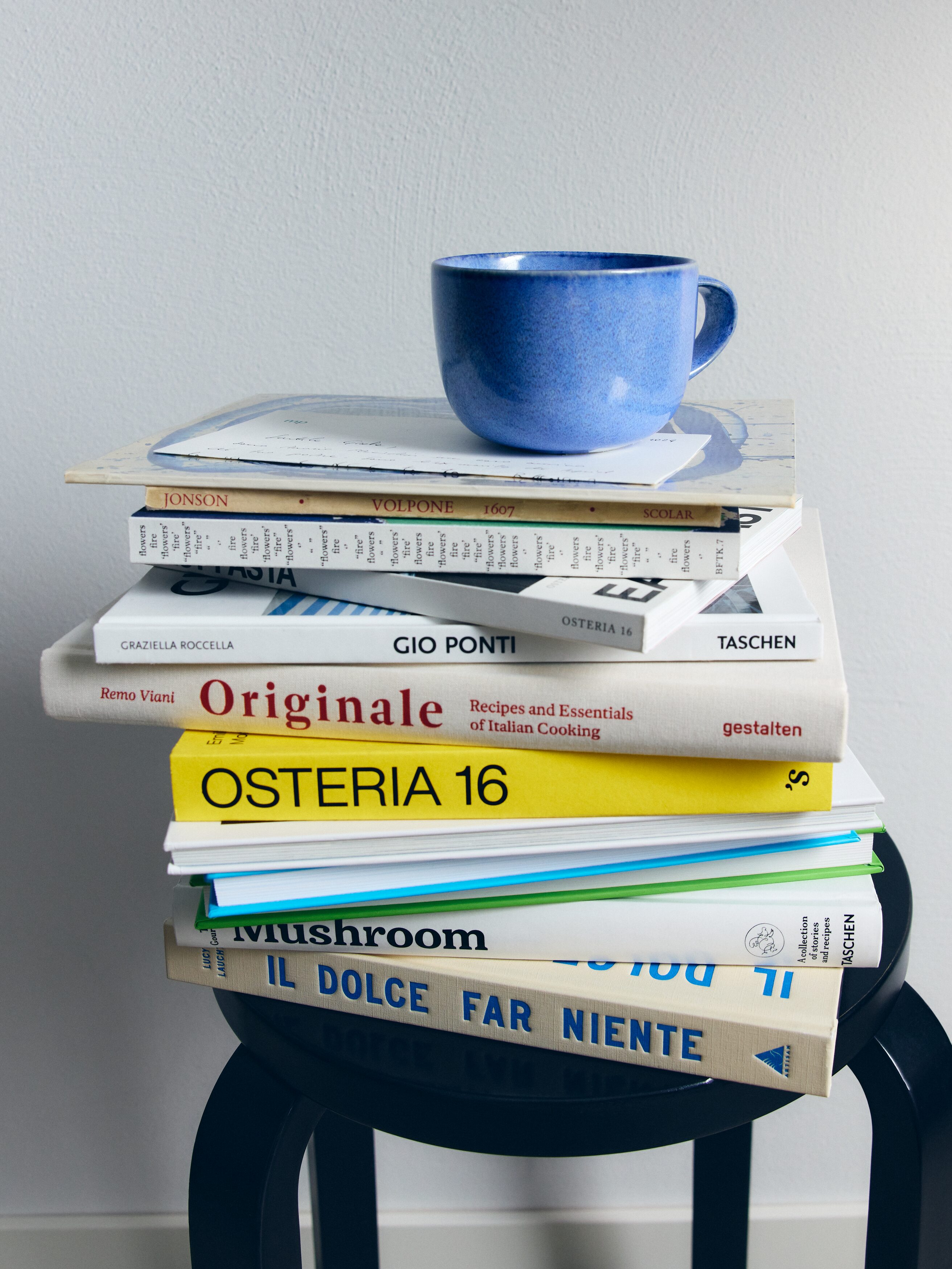 Kivitavarakuppi esittelee etupuoltaan, jossa on hieman epäsäännöllinen muoto ja vaaleansininen käsinmaalattu roiskekuvio, vastakohtana ruskea reuna ja kahvan sisäosa.