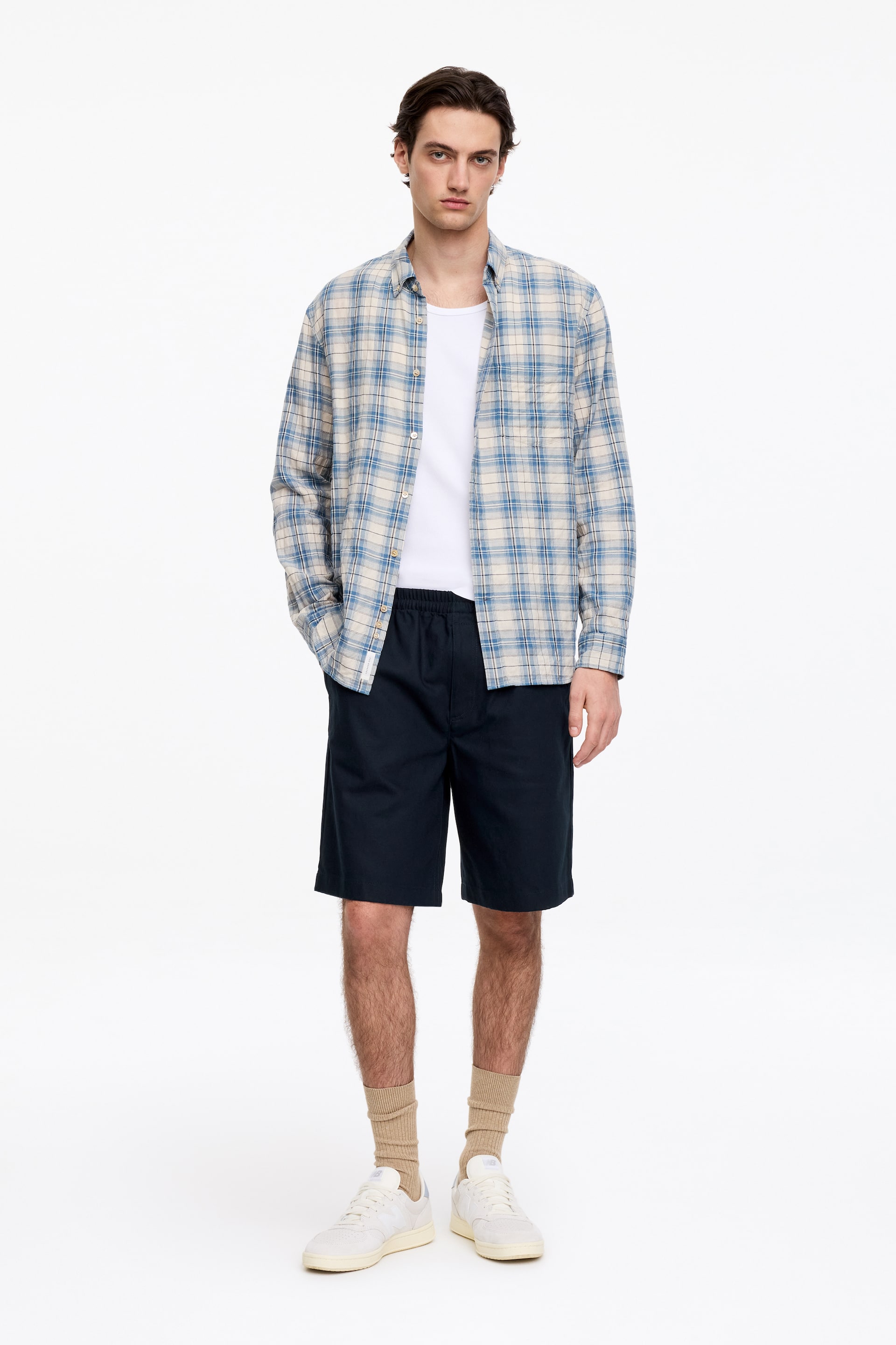 Visa större bild: Marinblå bomullsshorts med elastisk dragsko i midjan och sidfickor, som sträcker sig till ovanför knäet.