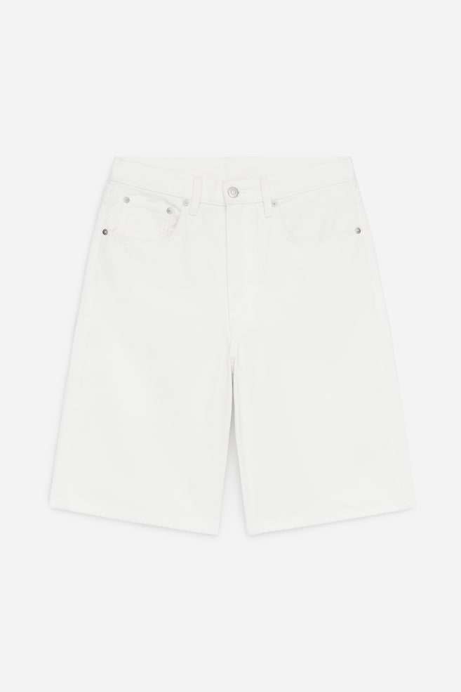White high-waist denim shorts, designed for a relaxed fit, are showcased from the front. They feature a classic 5-pocket style with two front pockets, a small coin pocket, and a button fly fastening. - 1