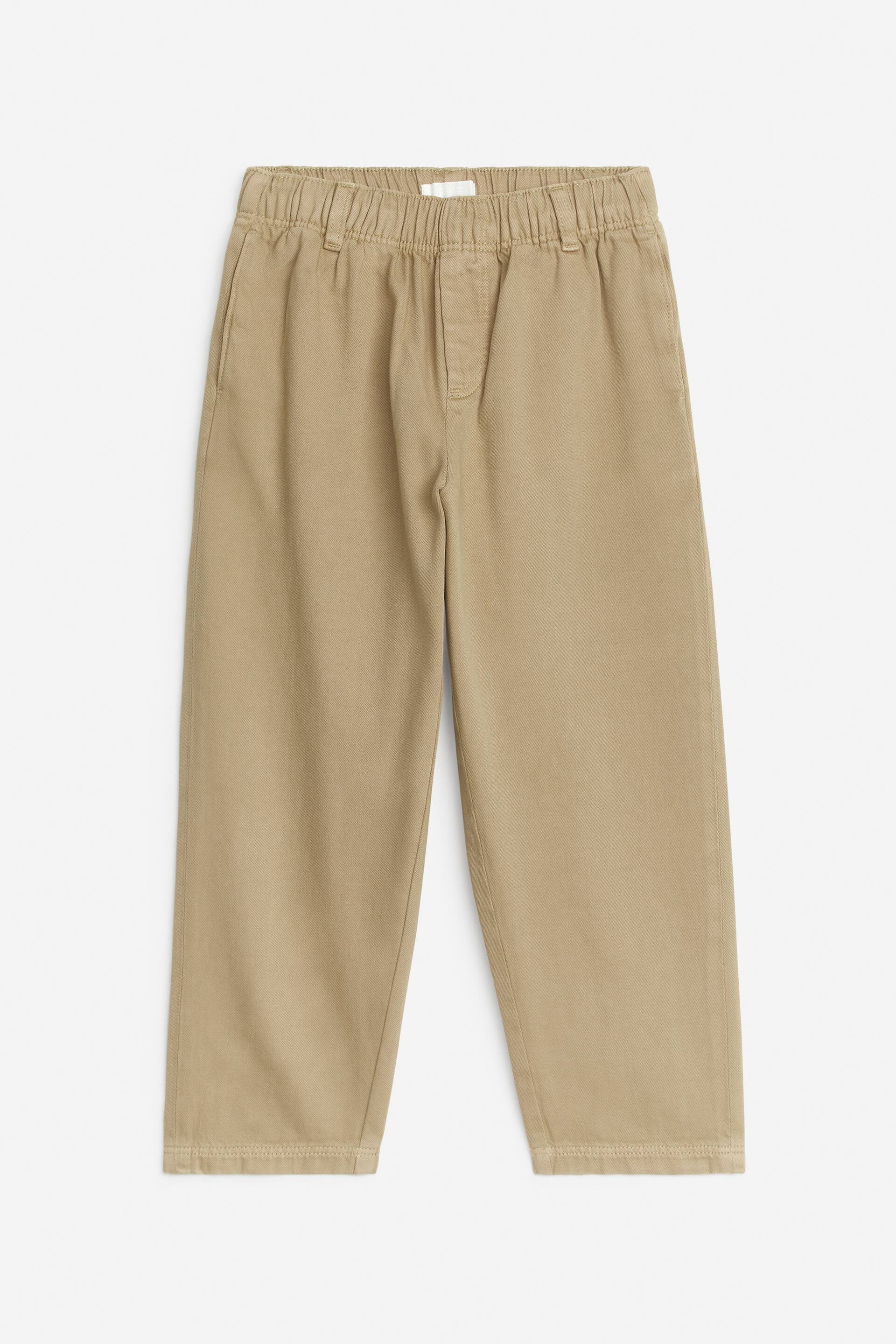 Se større billede: De khaki bukser har en elastisk linning med synlige bæltestropper og skrå indsatte sidelommer, præsenteret fra en front flad-lag visning. De er designet med en afslappet, lige ben pasform og syede sømme.