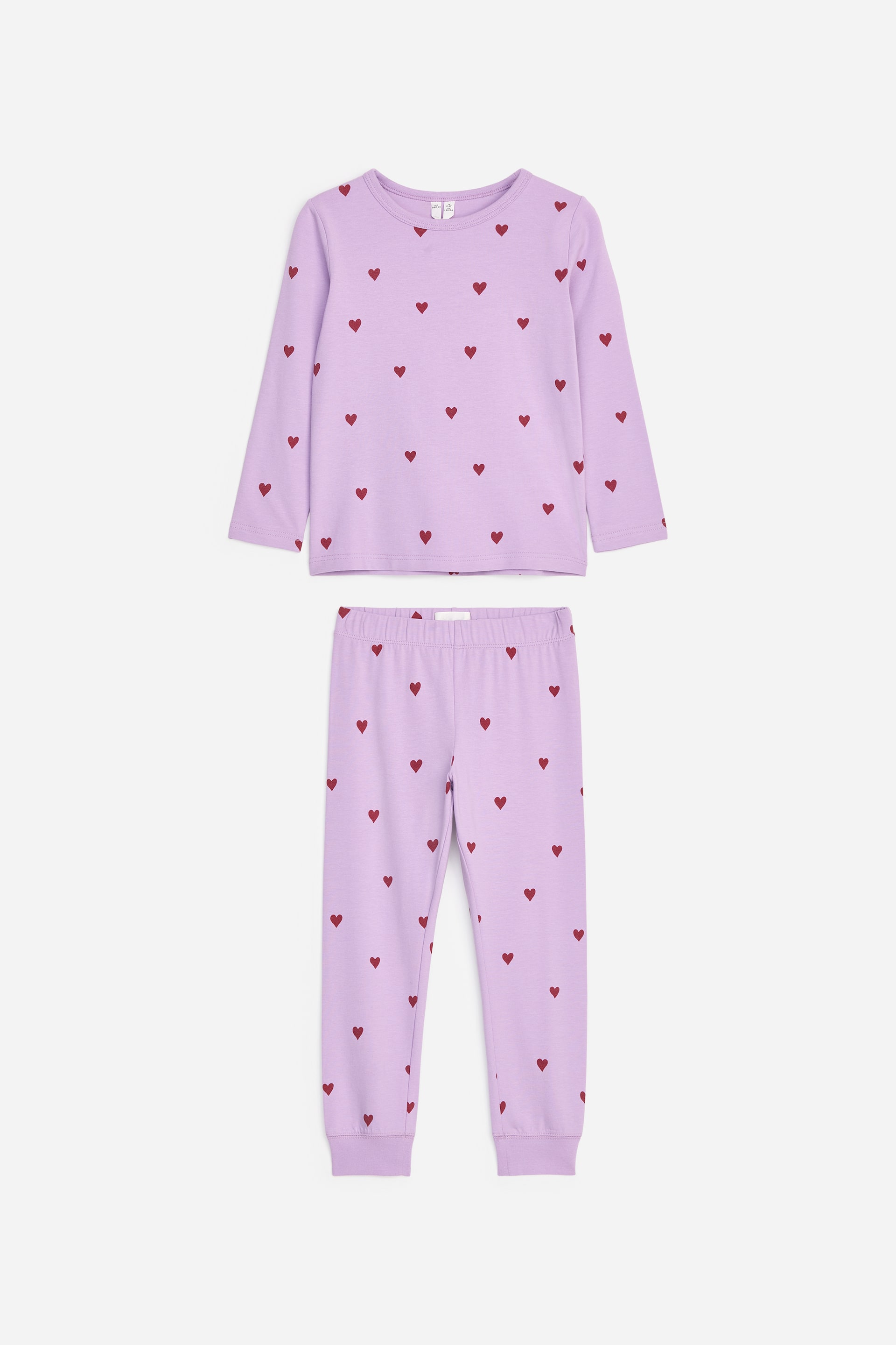 Agrandir l'image: Un ensemble de pyjama deux pièces violet clair comprenant un haut à manches longues à col ras du cou et un pantalon assorti, tous deux ornés d’un motif de cœurs rouges dispersés. Le haut et le pantalon présentent des poignets côtelés, et le pantalon est également doté d’une taille élastiquée.