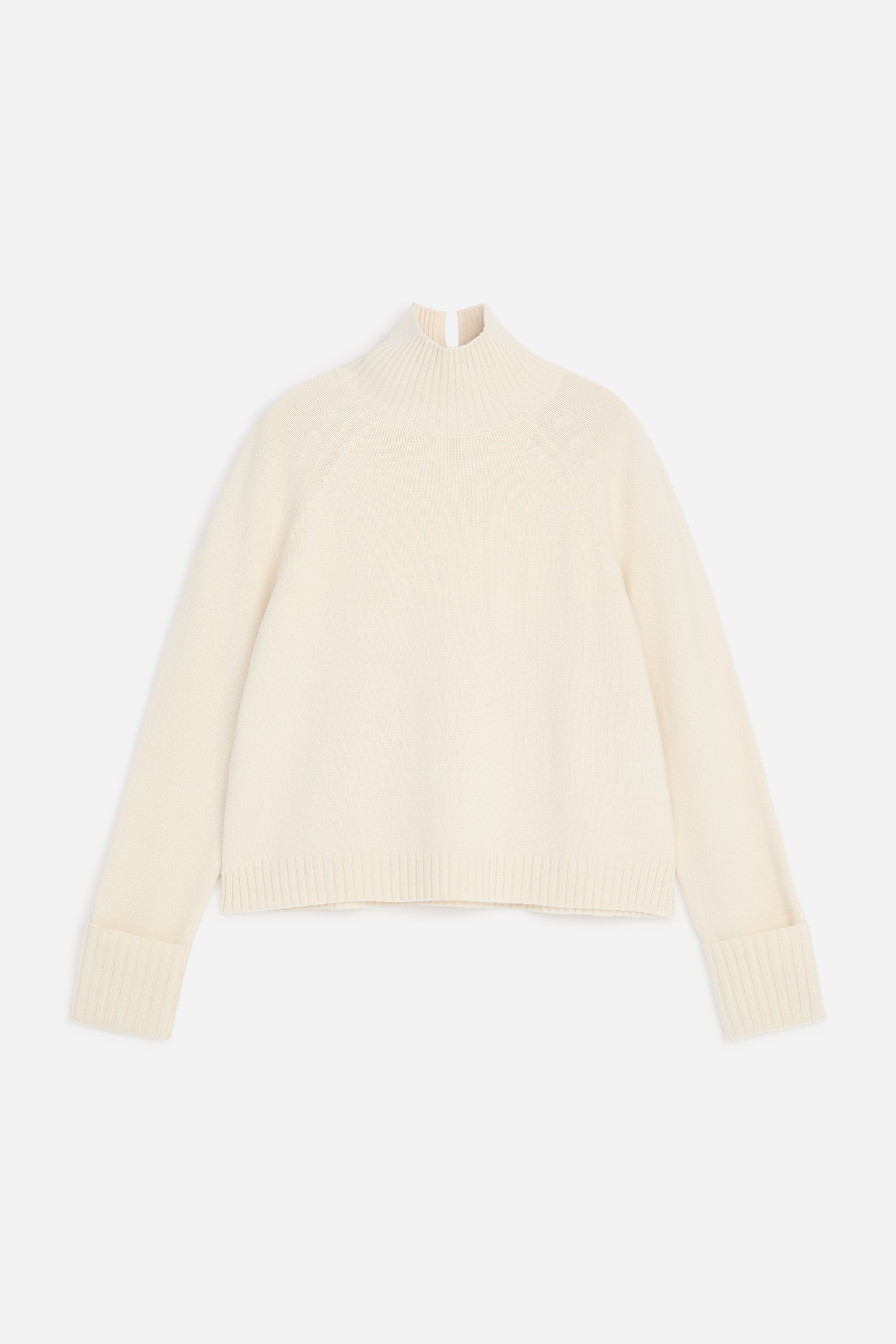 Um jumper de malha cor creme Ã© apresentado de frente, com gola alta canelada com abertura nas costas, mangas raglan e punhos largos canelados dobrados. A camisola apresenta um corte clÃ¡ssico com bainha canelada.