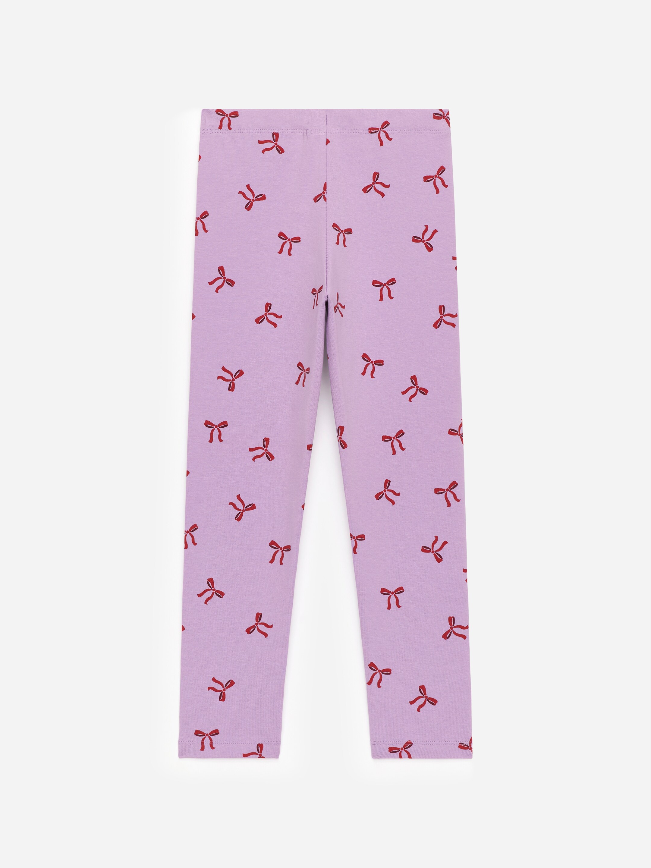 View larger image: Light purple leggings, made from a soft single jersey fabric, are lying flat. They are featuring a wide, flat waistband and are patterned all over with small, dark red bow ties.