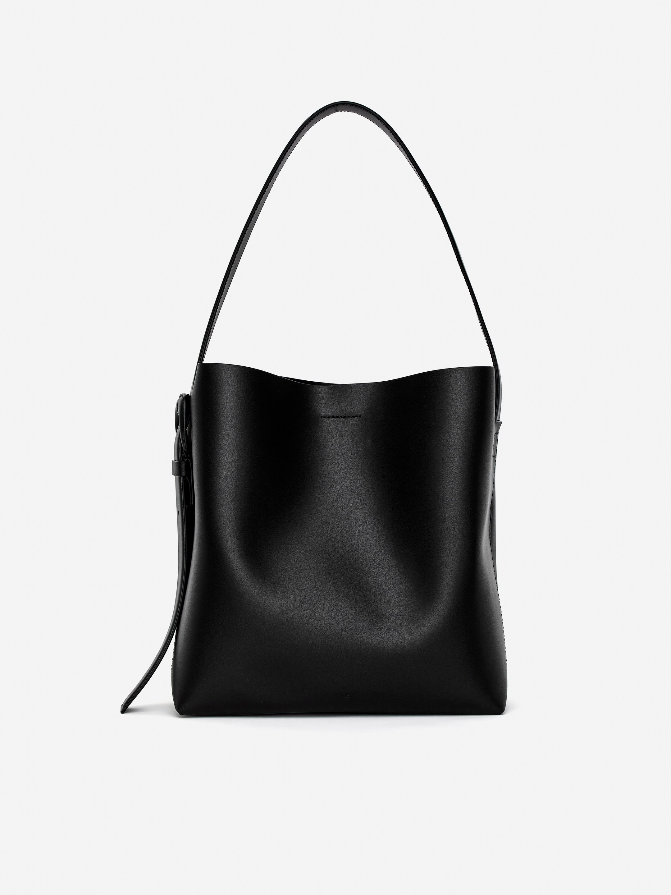 Größeres Bild anzeigen: Eine schwarze Tragetasche präsentiert ihre Vorderseite, mit einer strukturierten, halbsteifen Form und einer glatten, matten Oberfläche. Ihr geräumiges Design ist offensichtlich, und ein breiter Schulterriemen wölbt sich über die Tasche.