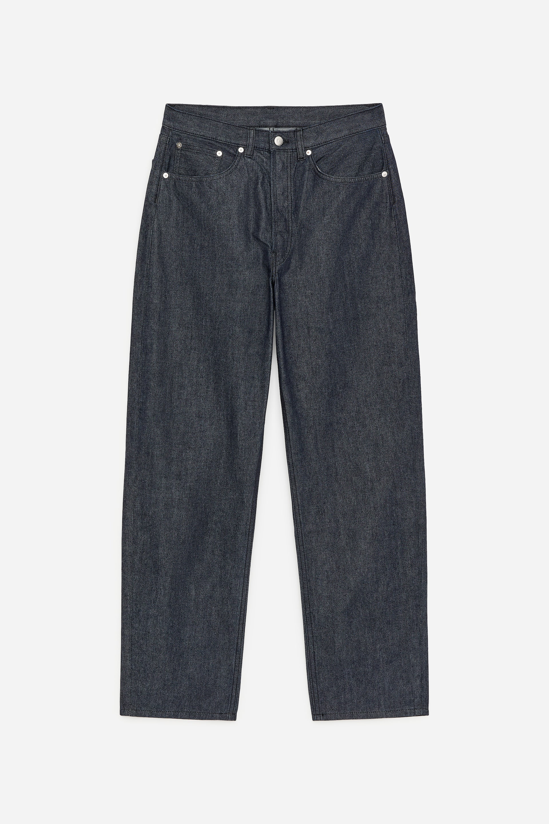 Visa större bild: Mörkt indigofärgade denimplagg i jeans visar en avslappnad, rak benvidd framifrån, med knappgylf, svängda framfickor med metalnitar och bälteshällor i den höga midjan.