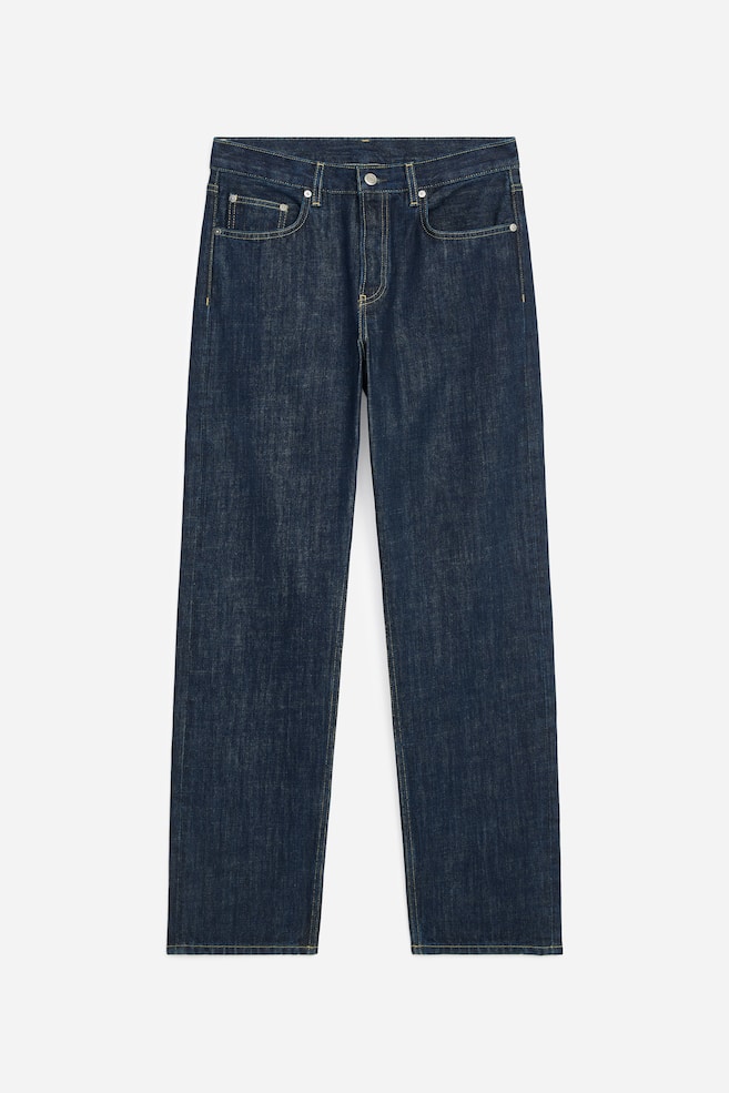 A pair of dark blue, straight-leg jeans is displaying a classic five-pocket design with contrast yellow stitching and a metal button fastening at the waistband from the front. The jeans are showcasing a mid-rise waist and a relaxed, full-length silhouette. - 1