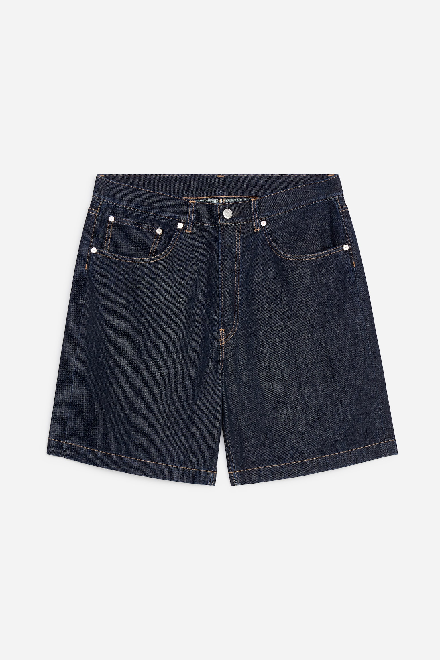 Pantalonii scurți din denim cu spălare închisă sunt vizibili din față, evidențiind cusături contrastante maro deschis, buzunare frontale cu nituri argintii și o închidere cu un singur nasture la talie.