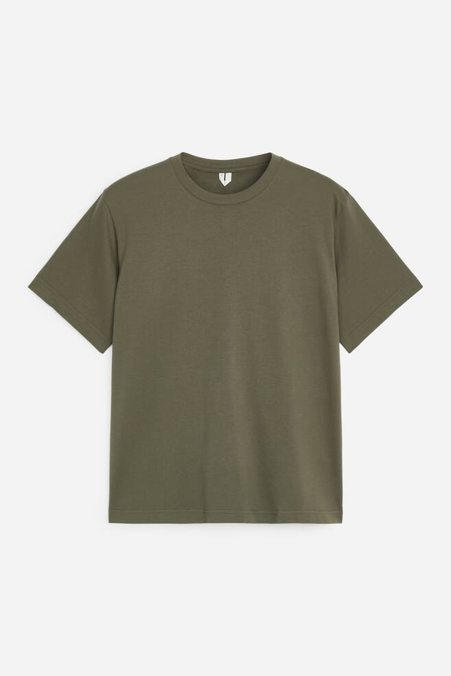 Een olijfgroen T-shirt met korte mouwen en ronde hals is van voren weergegeven, met een ontspannen pasvorm, een geribbelde kraag en een nette rechte zoom. - 1