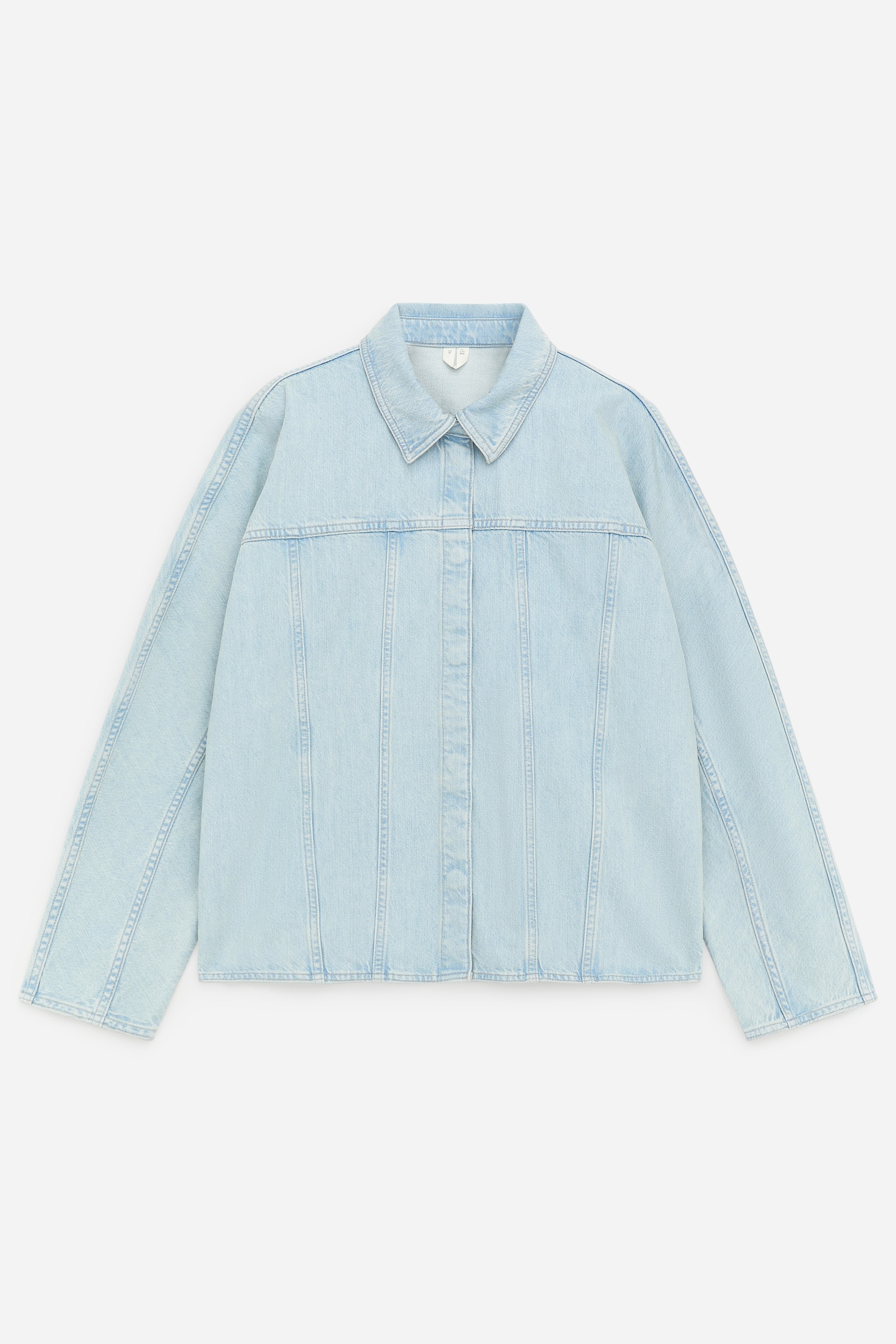 Zobacz większy obraz: Kurtka jeansowa w jasnoniebieskim odcieniu prezentuje swój przód, z charakterystycznym kołnierzem i ukrytym zapięciem na guziki. Pionowe szwy panelowe biegną wzdłuż przodu, a długie rękawy rozciągają się na boki.