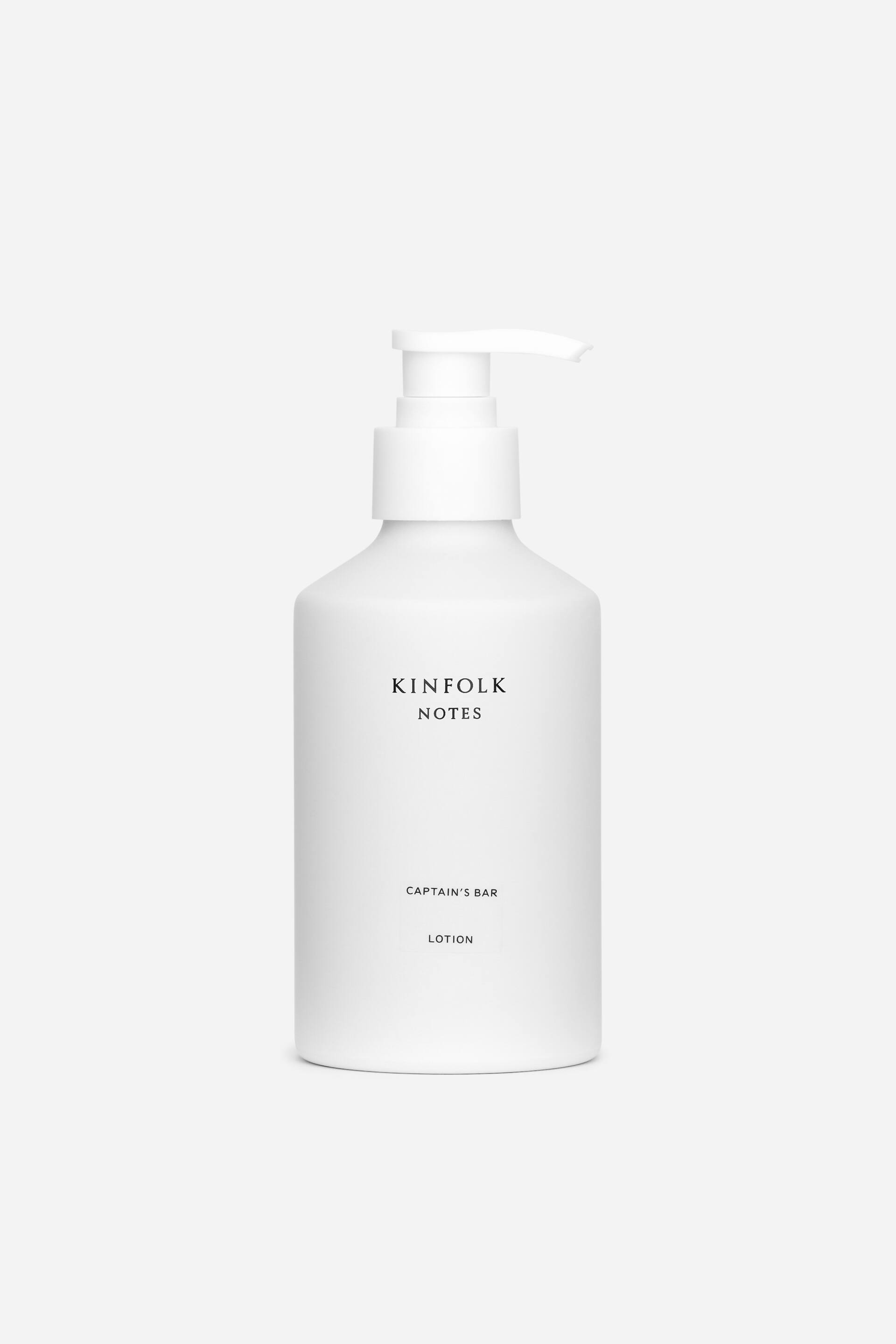 View larger image: A matte white bottle with a white pump dispenser is standing FRONT, displaying black text on its front surface that reads 'KINFOLK NOTES,' 'CAPTAIN'S BAR,' and 'LOTION.'