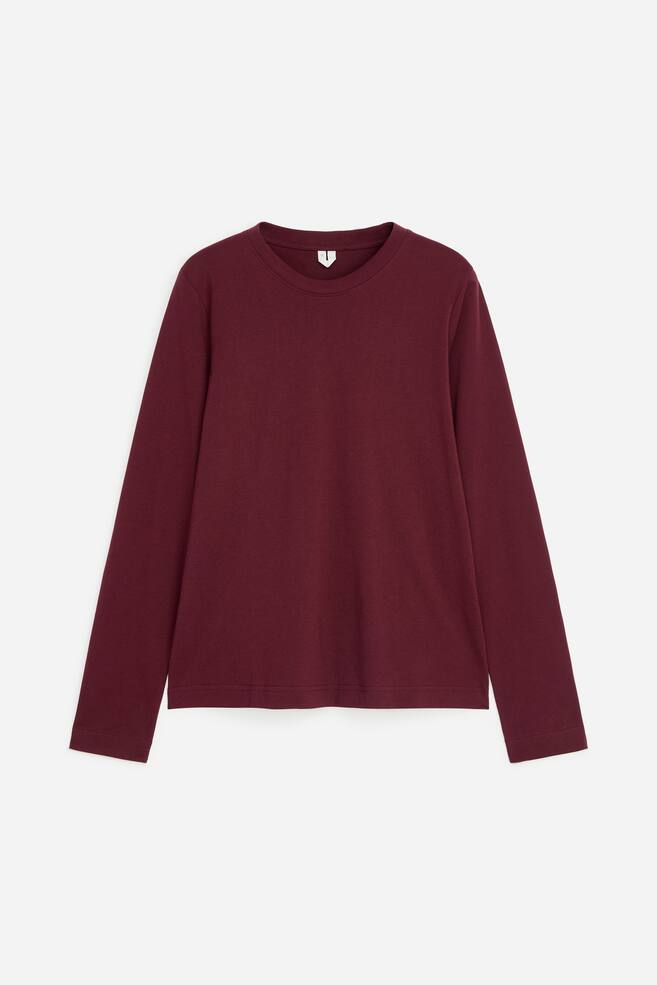 Vue de face dâun T-shirt Ã  manches longues bordeaux, mettant en valeur un col rond cÃ´telÃ© et des manches droites sans poignets. Le vÃªtement prÃ©sente une coupe rÃ©guliÃ¨re avec un ourlet droit et net. - 1