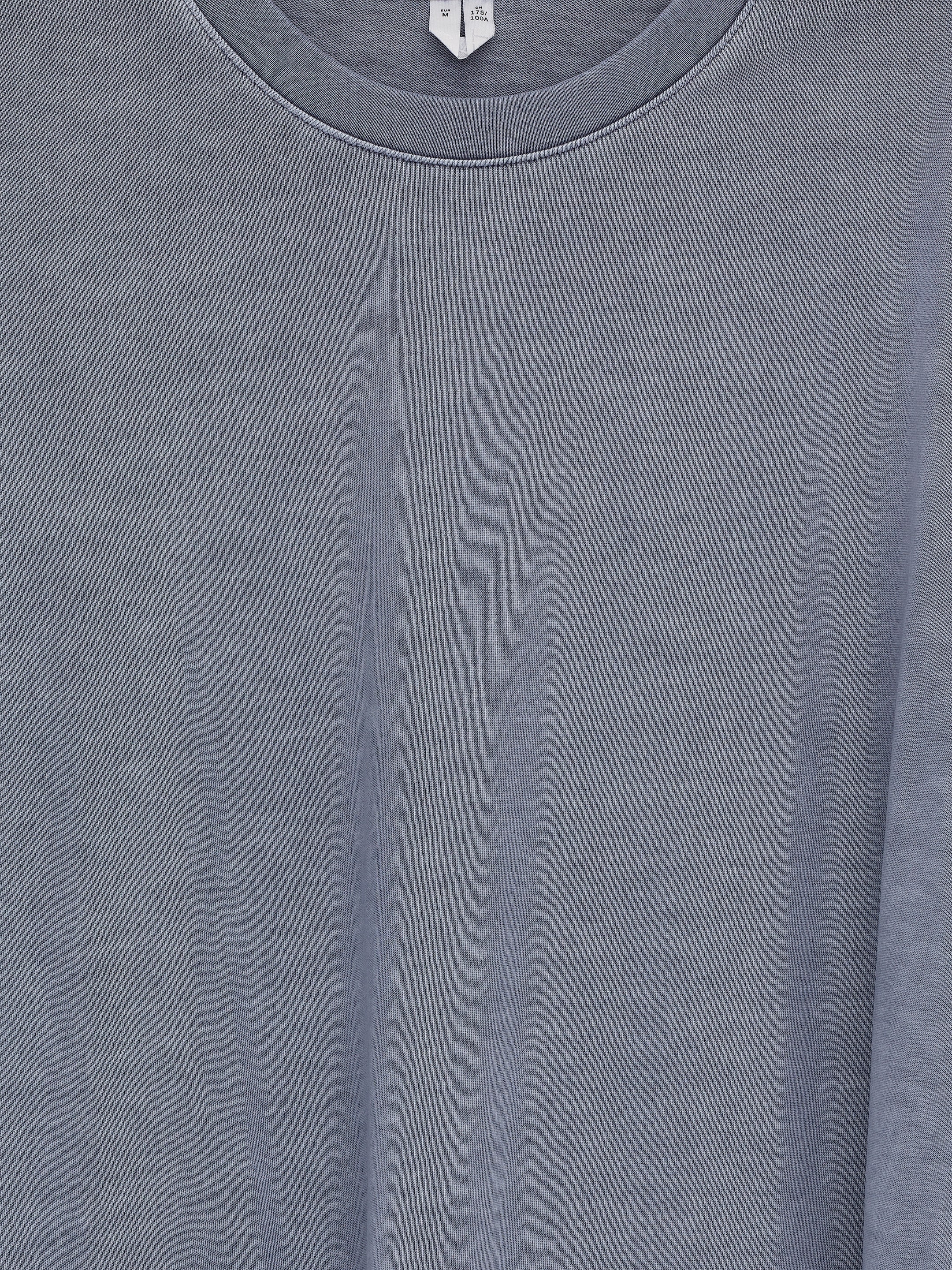 View larger image: A long-sleeved t-shirt is presented from the front, featuring a classic crew neck and a muted, washed-out grey color with a soft, cotton texture. A size label is visible at the back of the neck.
