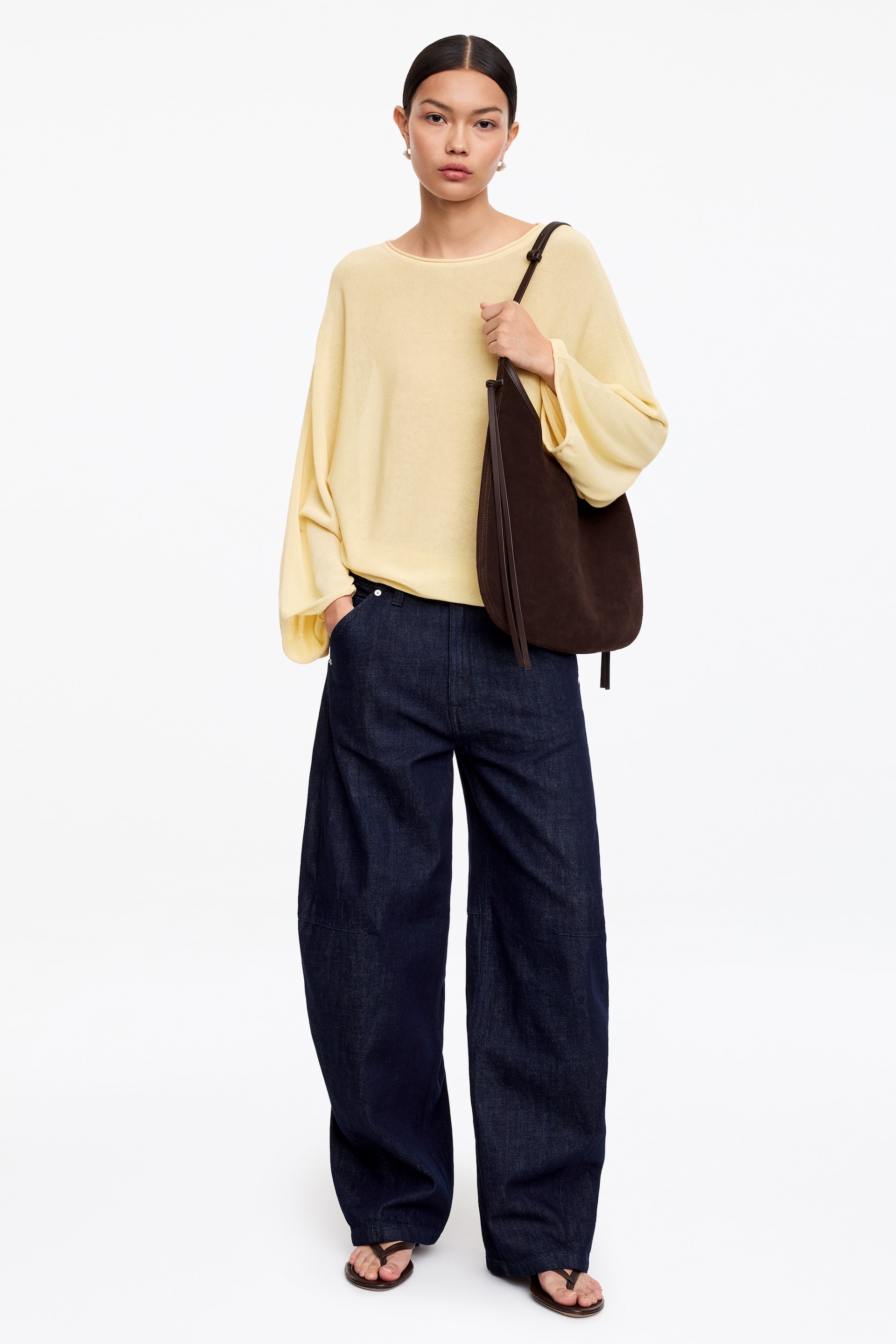 Größeres Bild anzeigen: Die dunkelblauen Denim-Jeans mit weitem Bein sitzen locker, zeichnen sich durch sichtbare Nähte an den Beinen aus und reichen bis zum Boden.