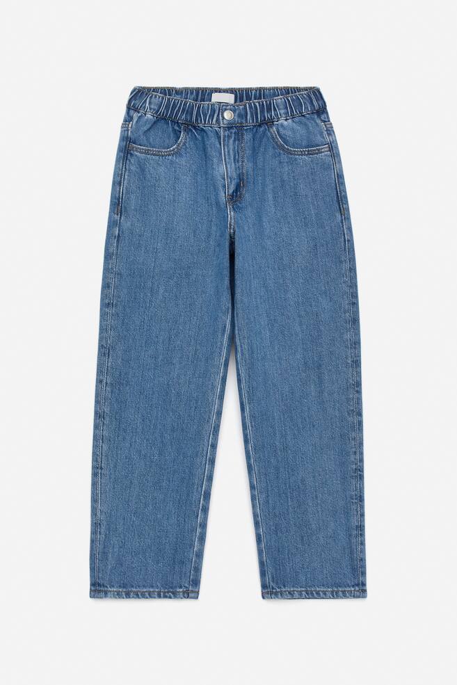 Blue denim jeans are presenting FRONT, featuring a wide fit and straight legs. They are designed with an elasticated waistband, a single button closure, and two angled front pockets. - 1