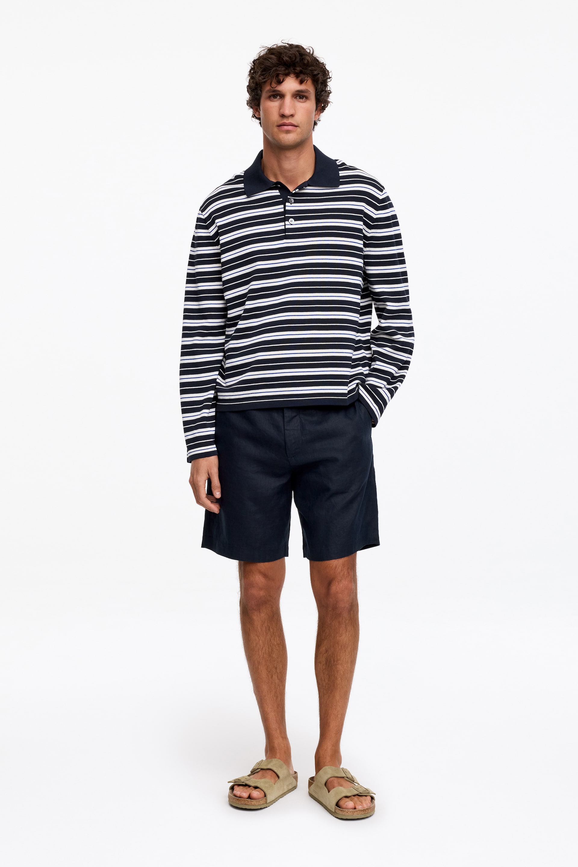 Größeres Bild ansehen: Leinenshorts werden vom Modell getragen. Diese Shorts zeigen einen Schnitt in mittlerer Oberschenkellänge, eine reguläre Passform, einen sichtbaren Reißverschluss mit Knopfverschluss und schräge Vordertaschen.