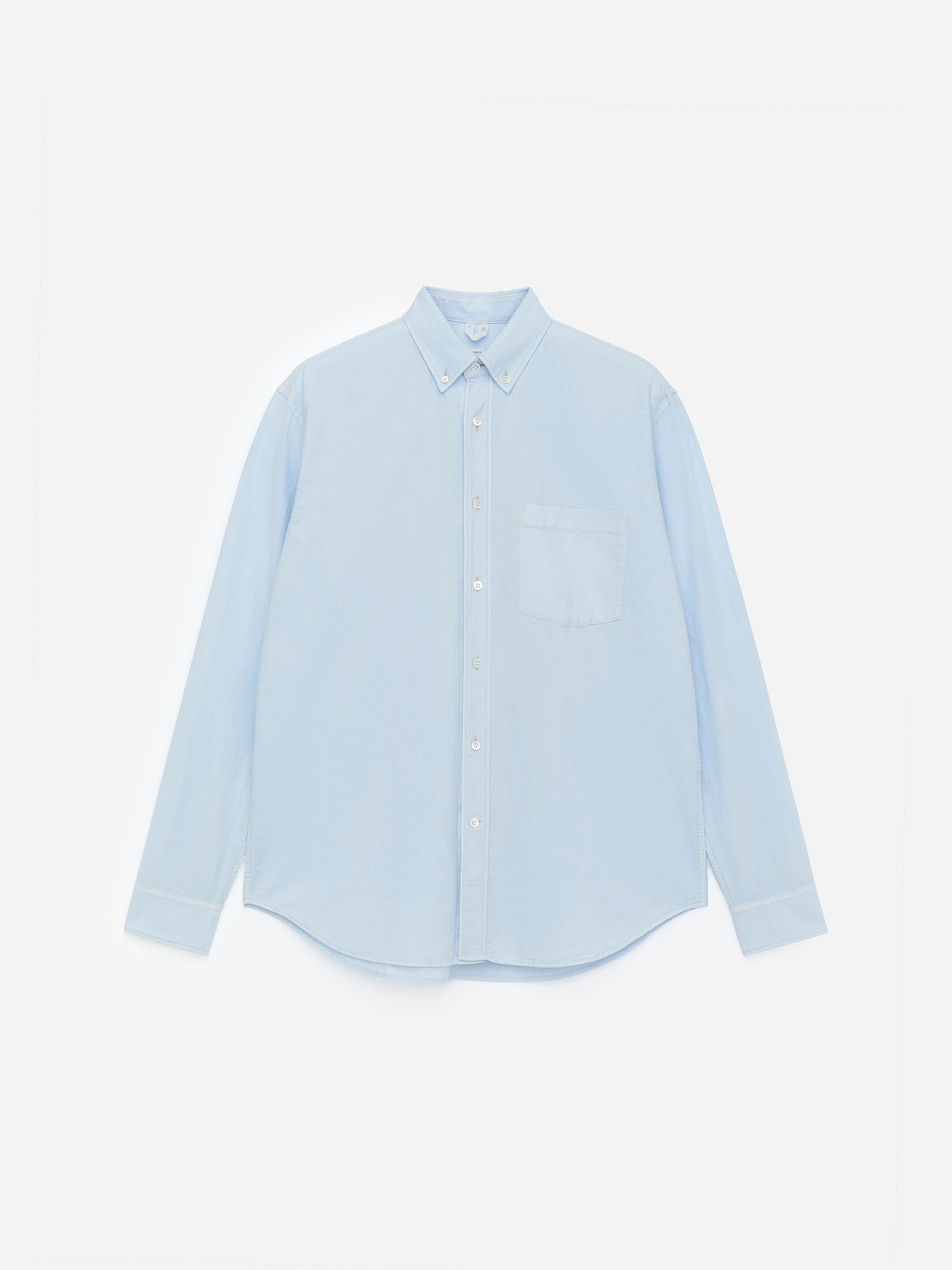 Agrandir l'image: Une chemise en tissage Oxford en coton bleu clair est présentée de face, arborant un style décontracté et des coutures blanches visibles. Elle est conçue avec un col boutonné, une patte de boutonnage complète assurant des boutons en nacre, une poche poitrine unique, des manches longues avec des poignets boutonnés et un ourlet arrondi.