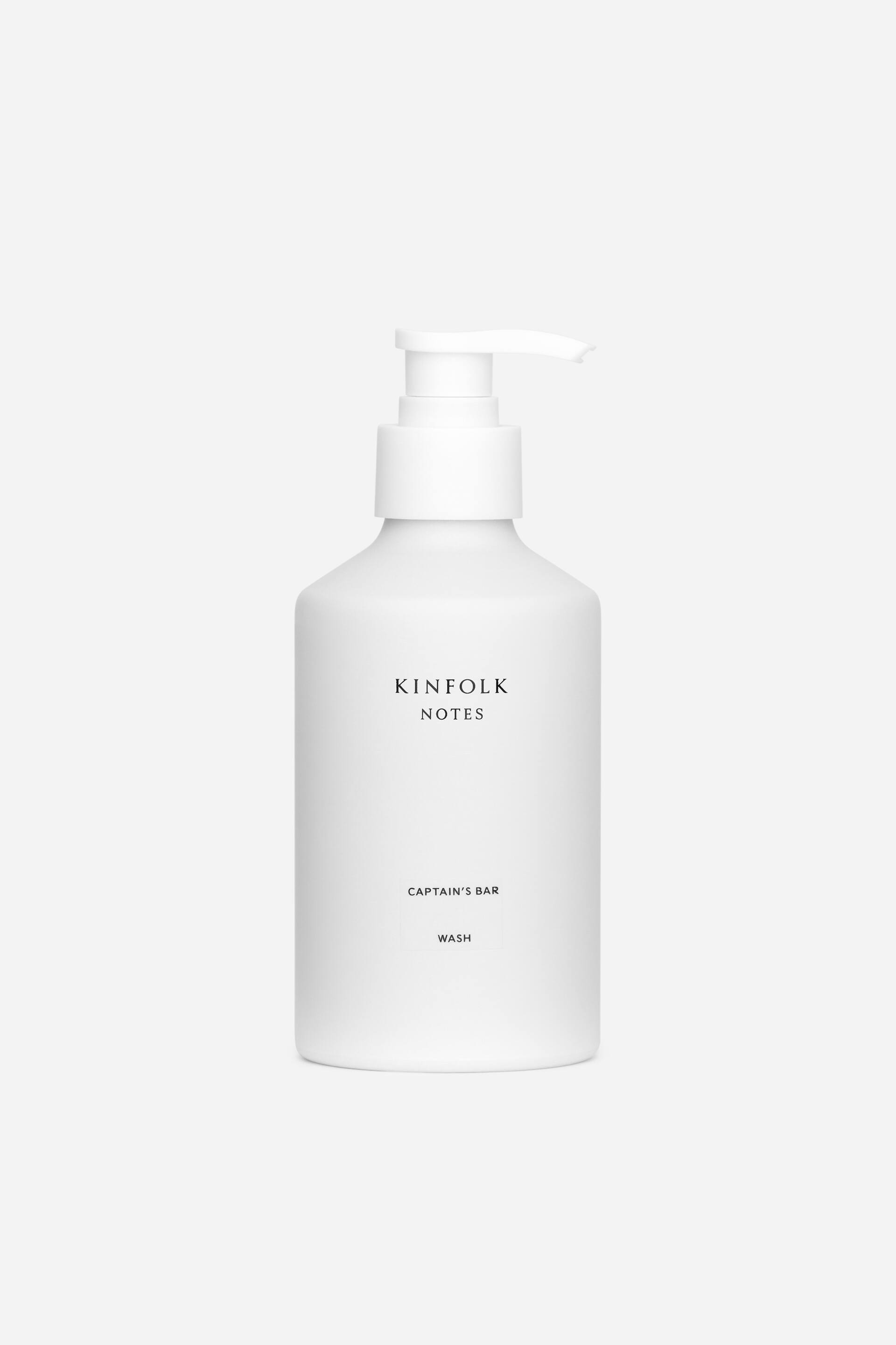 Grotere afbeelding bekijken: Een witte, matte pompflacon staat frontaal gericht, met een cilindrische body en afgeronde schouders, een witte pompdispenser, en zwarte tekst 'KINFLOK NOTES' en 'CAPTAIN'S BAR WASH' gecentreerd op de voorkant.