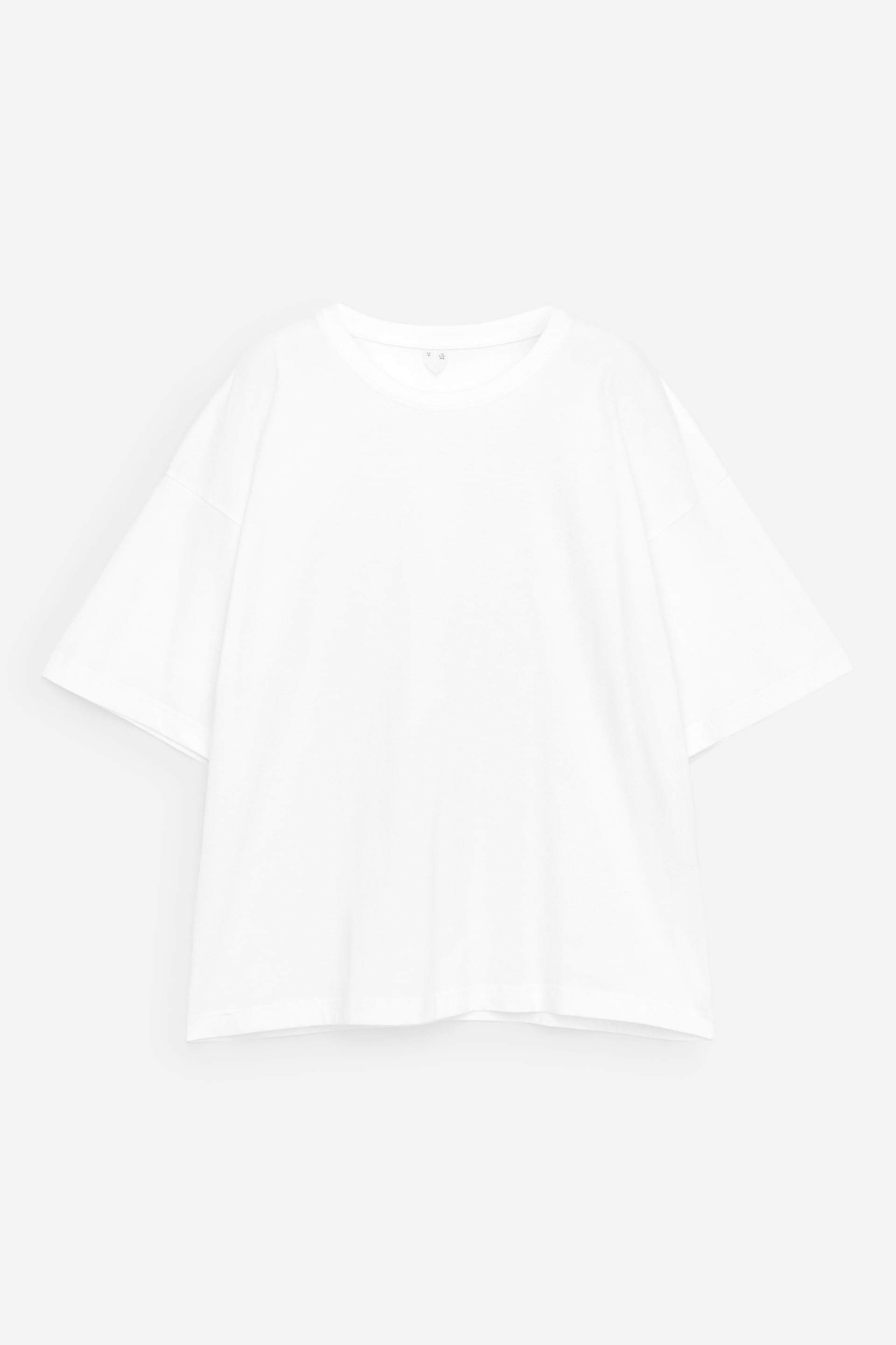 View larger image: A white t-shirt is displayed from the front, featuring a ribbed crew neck and short, wide sleeves with dropped shoulders, offering an oversized fit with a straight hem.