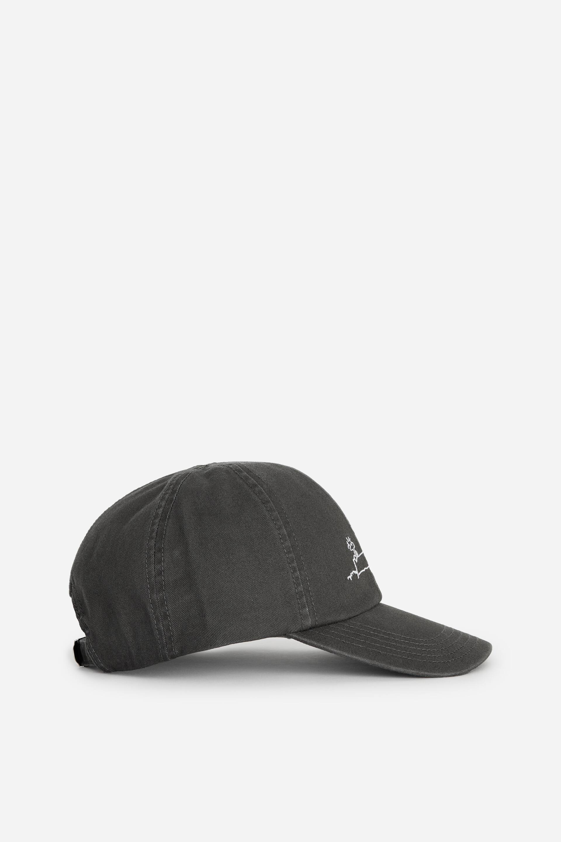 Ver imagem maior: Um boné de basebol cinzento escuro está a mostrar o seu perfil lateral, apresentando uma coroa suave e não estruturada com costura visível, uma aba curva e um design bordado a branco no painel frontal.