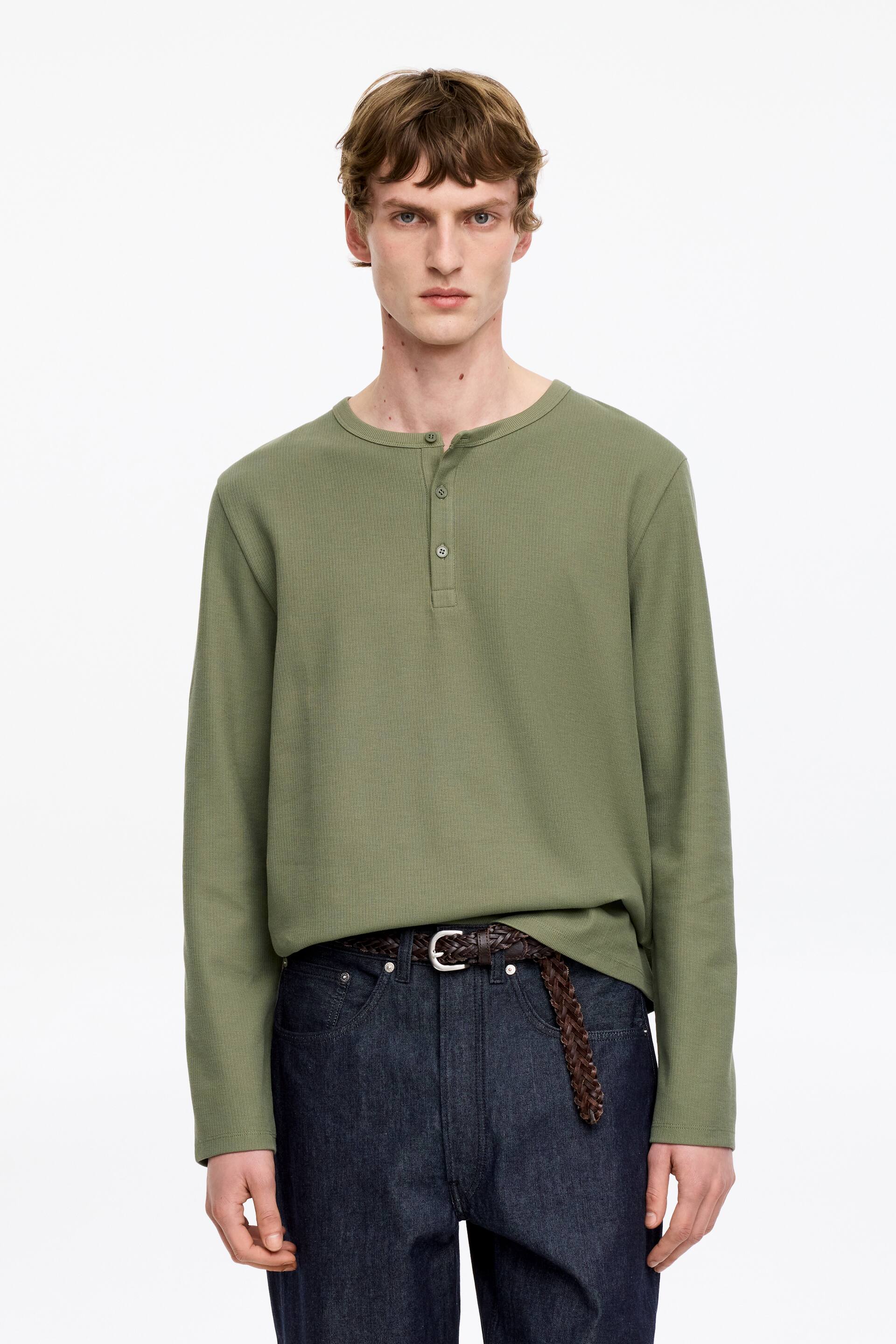 Agrandir l'image: Une chemise Henley à manches longues vert olive, dotée d'un col rond avec une patte de boutonnage à trois boutons, présente une texture en maille gaufrée et une coupe décontractée.