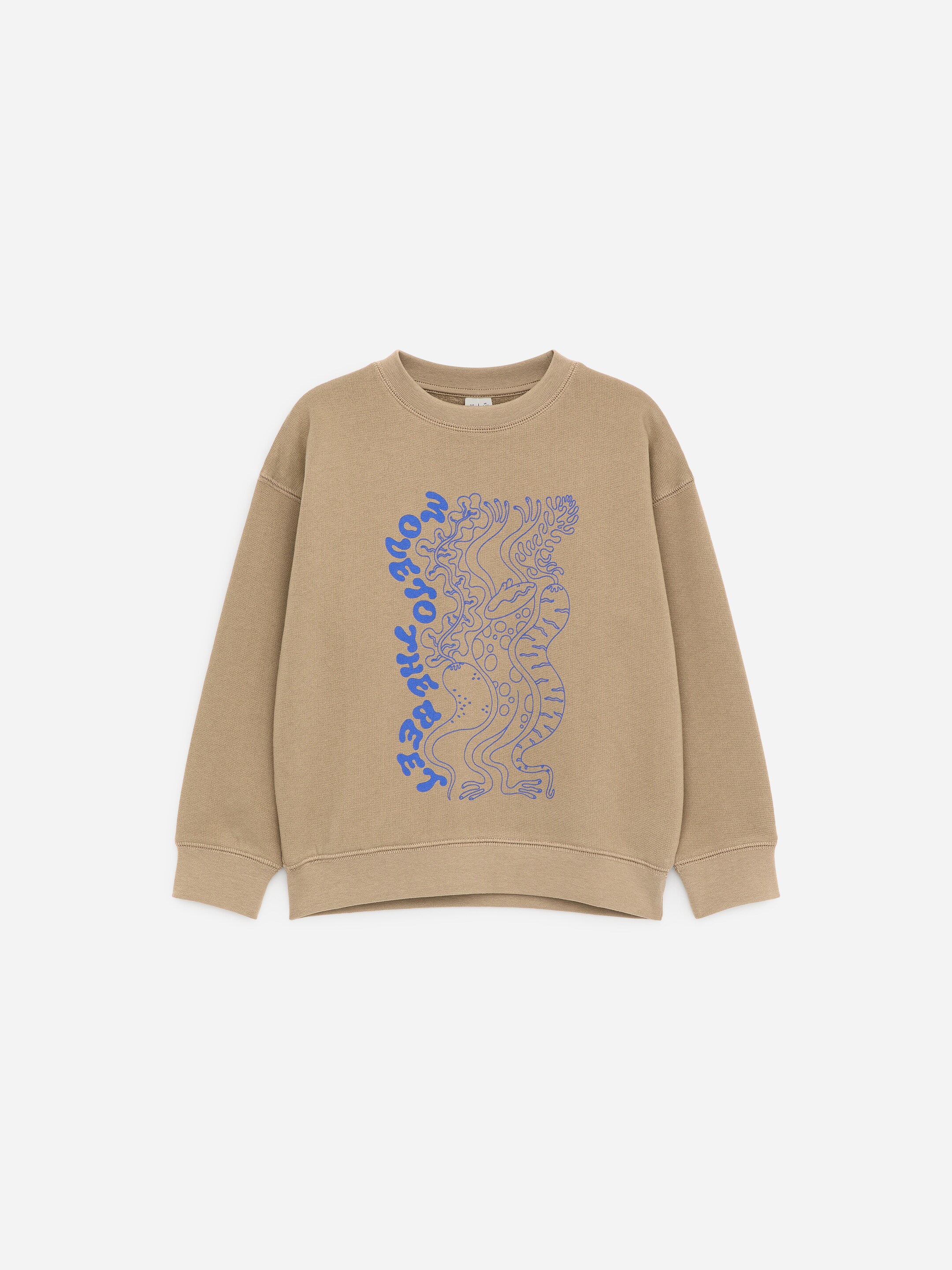 Grotere afbeelding bekijken: Een lichtbruin sweatshirt toont de VOORKANT, met een blauwe grafische print met de gestileerde tekst "MOVE TO THREE" verticaal aan de linkerkant, naast een abstract golvend motief. Het is uitgevoerd met een crew-neck en afgewerkt met geribde boorden bij de kraag, de manchetten en de zoom.