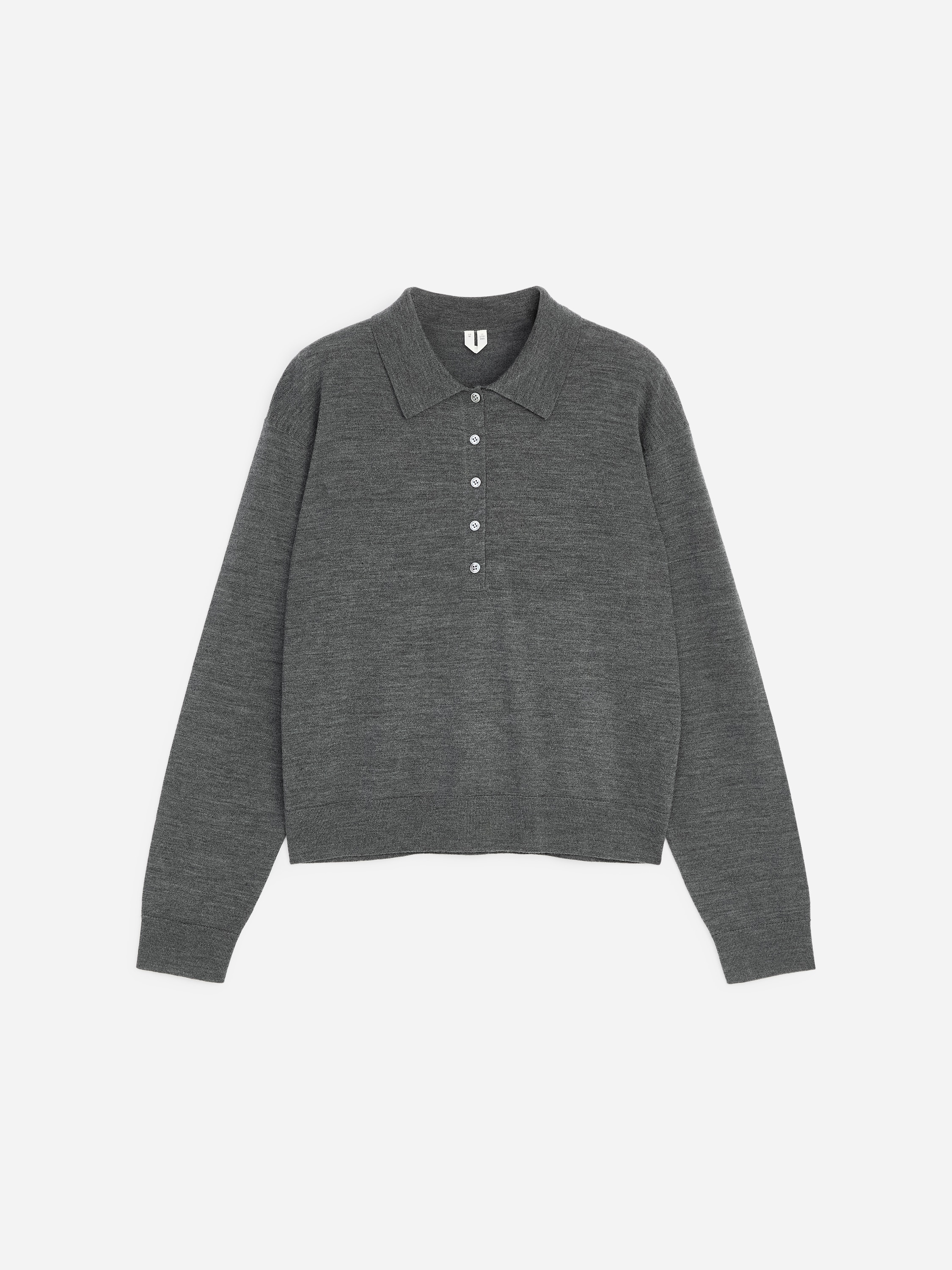 Een grijze gebreide poloshirt wordt gedragen door het model, weergegeven van achteren om de Franse schoudernaden, de lange mouwen en de geribbelde zoom te benadrukken. Het shirt wordt gecombineerd met een bijpassende grijze broek met wijde pijpen.