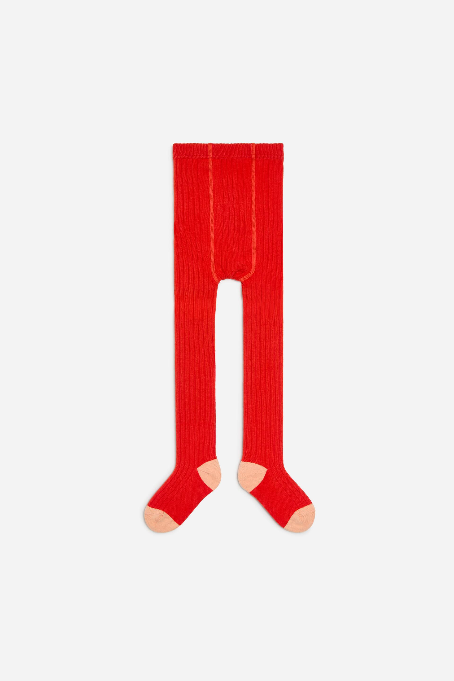 Ver imagen más grande: Las medias de punto de canalé en rojo vivo se muestran de frente, con una textura acanalada vertical y una cintura elástica. El diseño se completa con talones y punteras en color melocotón en contraste.