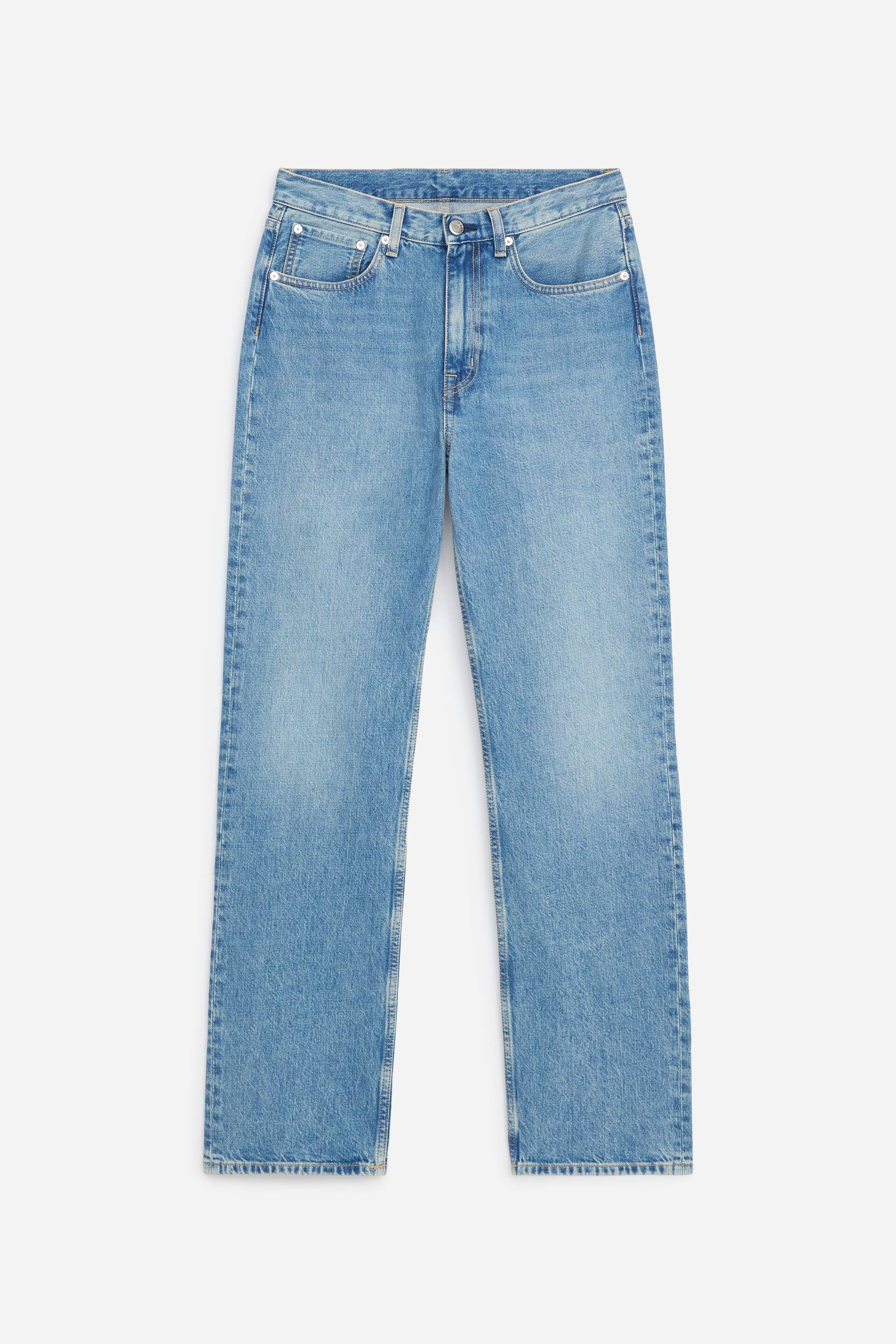 Grotere afbeelding bekijken: Een lichtblauwe denimjeans wordt van voren getoond en benadrukt een middelhoge taille, rechte pijpen en een klassiek ontwerp met vijf zakken. De jeans vertoont subtiele vervaging aan de dijen en heeft een knoopsluiting aan de tailleband.