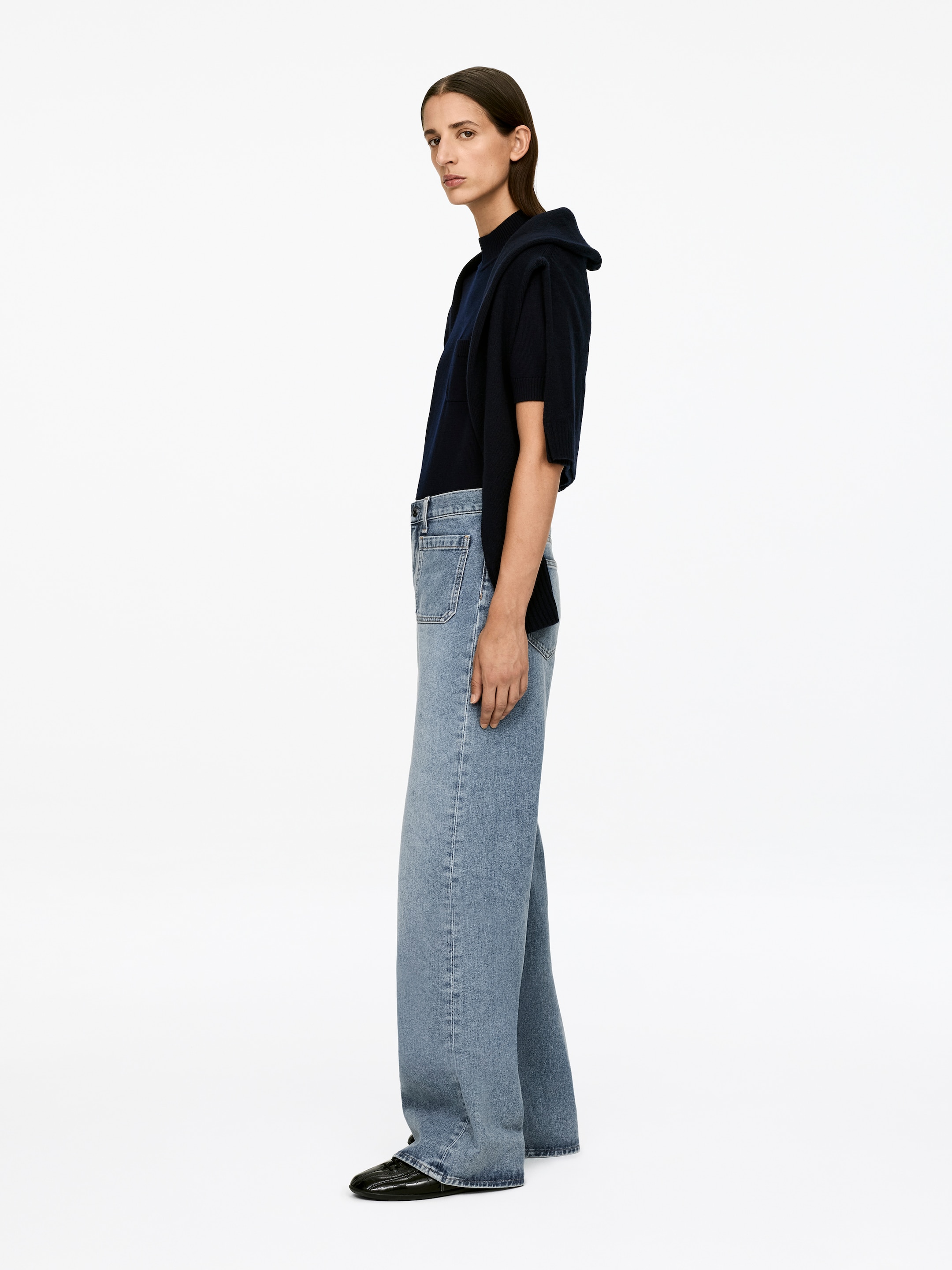 Visualizza immagine più grande: I jeans di denim azzurro chiaro, con vita alta, vestibilità aderente sulle cosce, gambe svasate e tasche frontali con pattina visibili, sono indossati dalla modella.