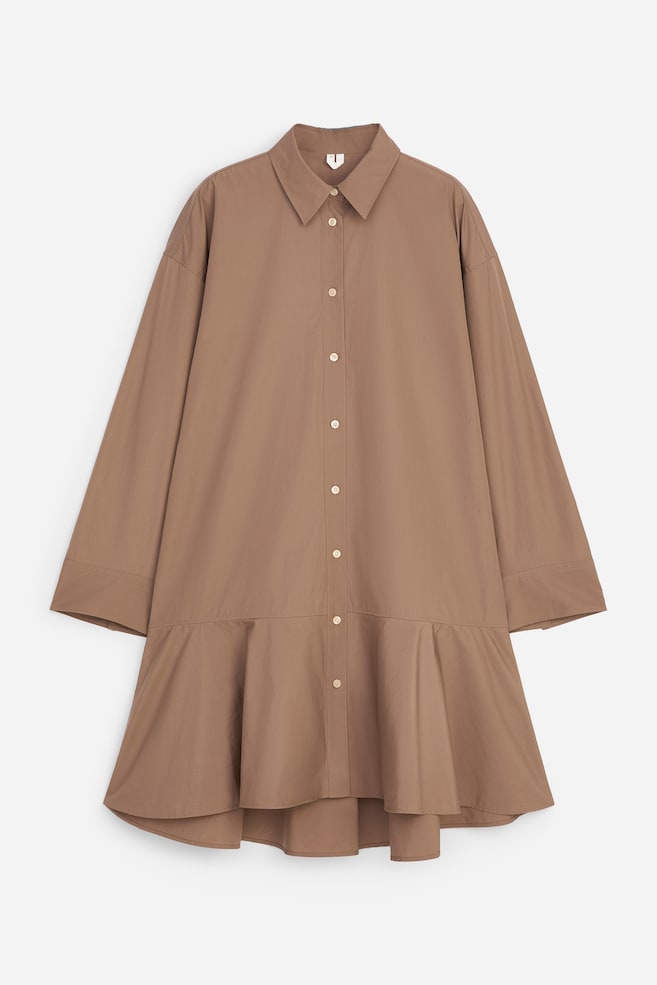 A brown cotton shirt dress is shown from the front, featuring a classic pointed collar, a button-through front, and dropped-shoulder long sleeves with wide cuffs. The relaxed-fit design flares at the hem with a gathered peplum detail. - 1