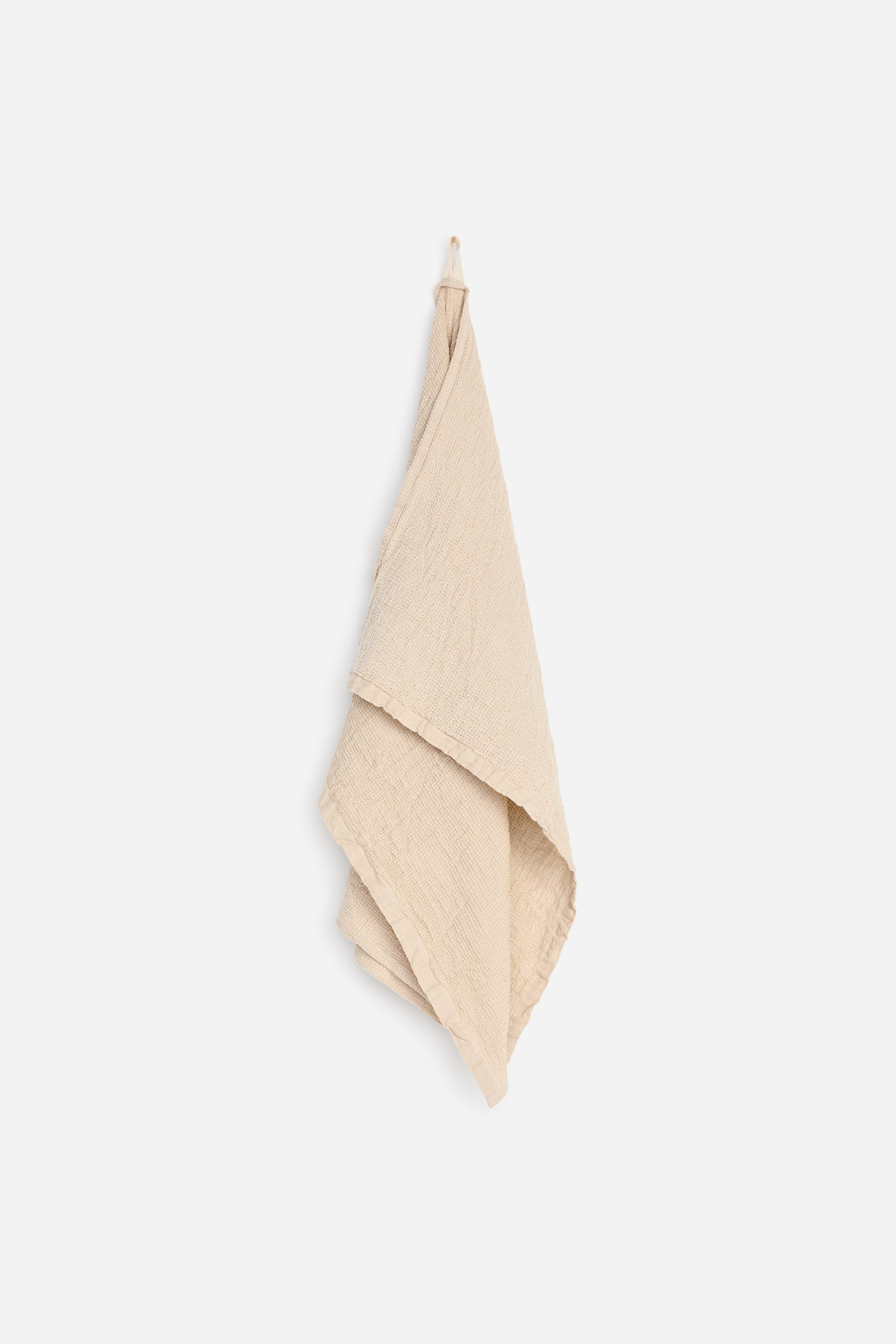 Visualizza immagine più grande: Un asciugamano beige chiaro è appeso a un anello, mostrando la sua texture increspata mentre è piegato.