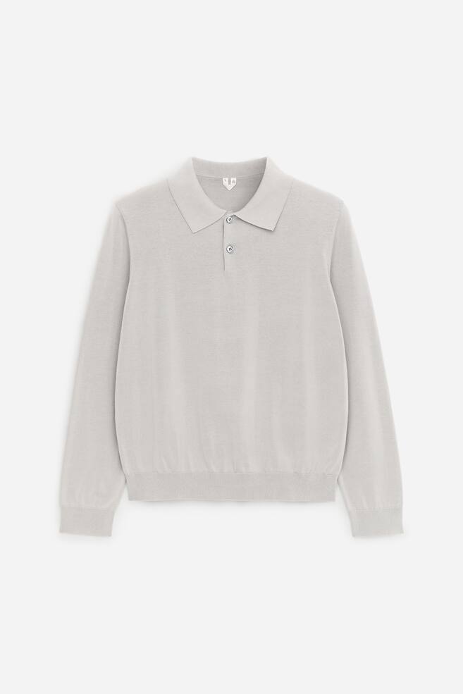 A light-grey long-sleeved knitted polo shirt is shown from the front, featuring a classic collar, a two-button placket, ribbed cuffs and a ribbed hem. - 1