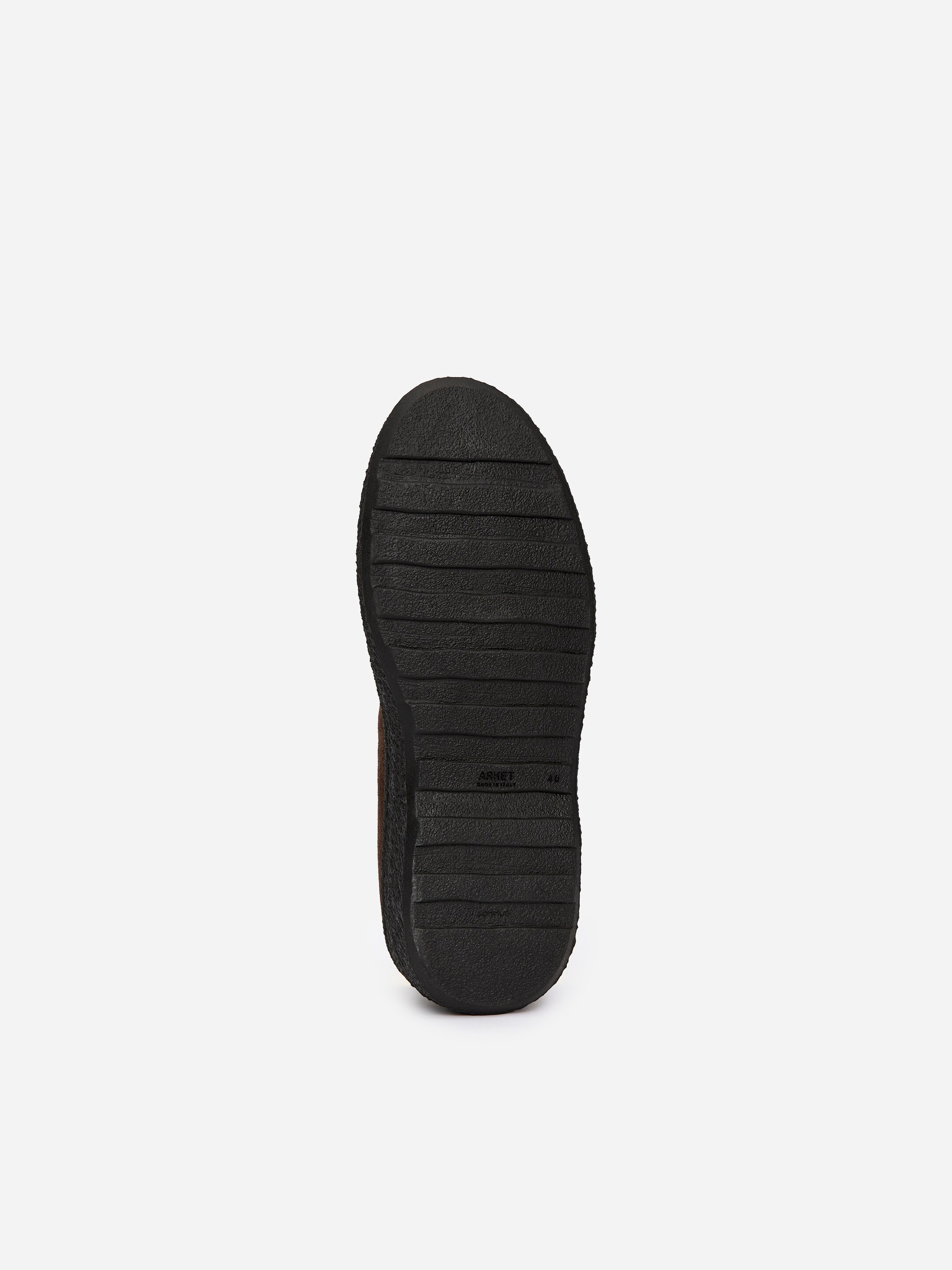 Agrandir l'image: Une semelle de chaussure en caoutchouc noir affiche des crêtes horizontales pour la traction, avec les mentions de la marque "ARKET," "MADE IN ITALY," et la taille "40" imprimées près du talon.