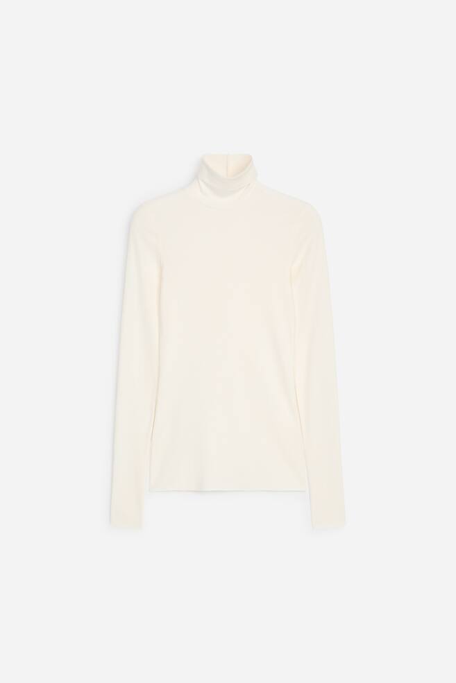 A cream-coloured roll-neck jersey top is shown in a front-facing view, showcasing its long sleeves and slim-fit silhouette. The top features a high, folded roll-neck collar, a straight hem, and a lightweight, sheer-finish texture. - 1
