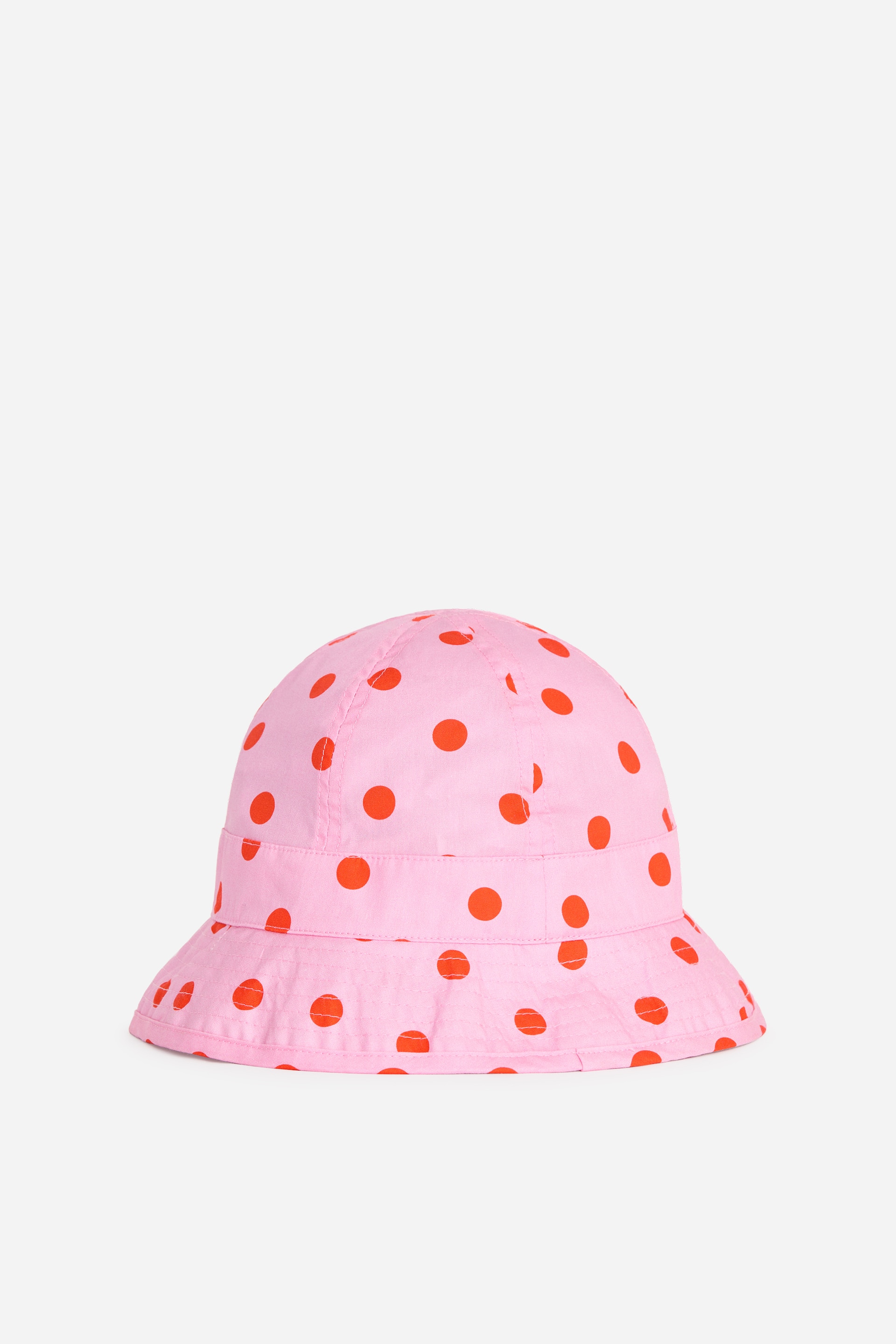 Zobrazit větší obrázek: Růžový kbelíkový klobouk s červenými puntíky, měkkou korunou a širokou, mírně zvlněnou krempou.