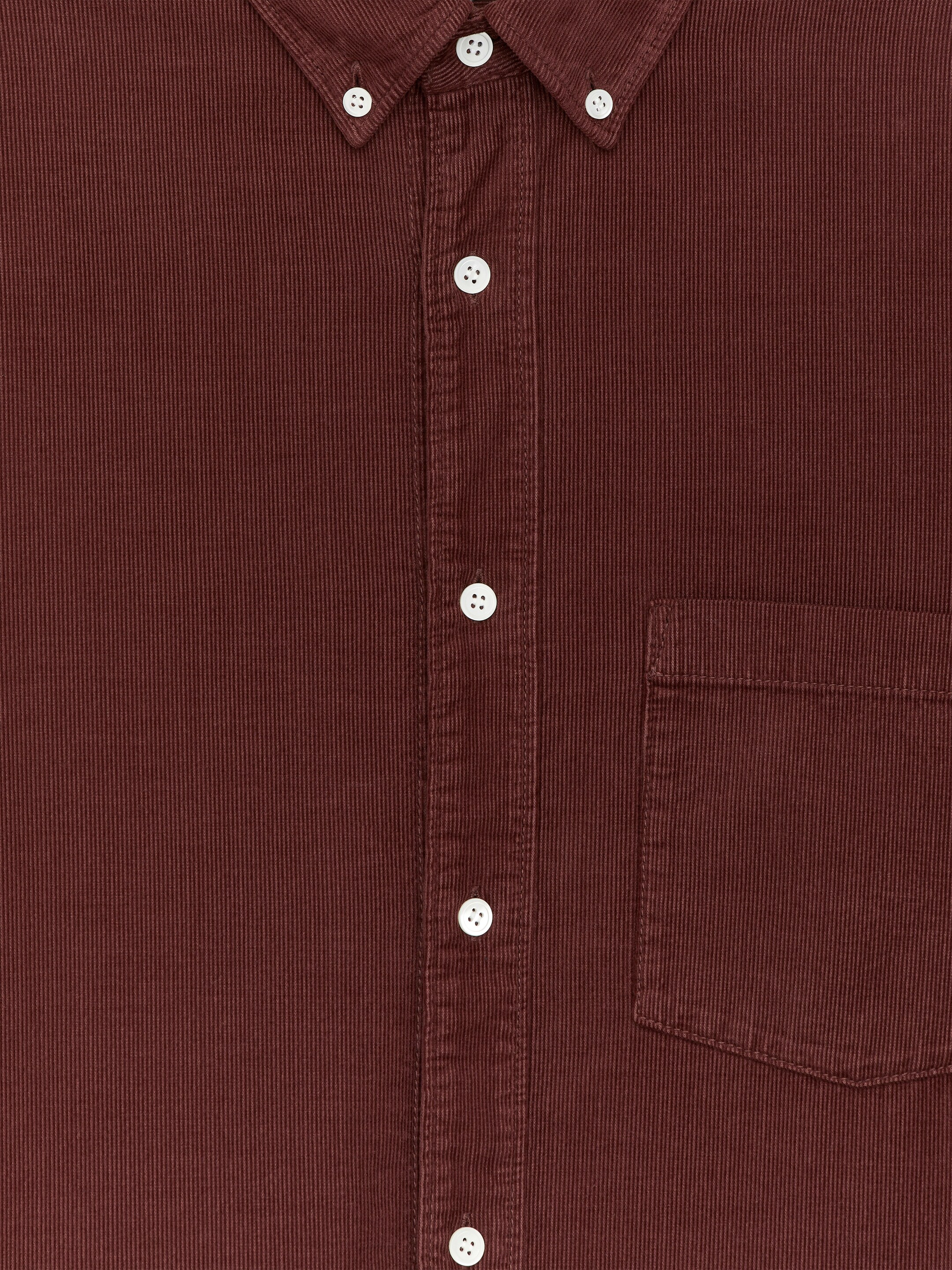 Größeres Bild anzeigen: Ein tief rotbraunes Feincordhemd wird von vorne präsentiert, mit einem Button-Down-Kragen, einer Knopfleiste mit weißen Knöpfen und einer einzelnen Brusttasche.