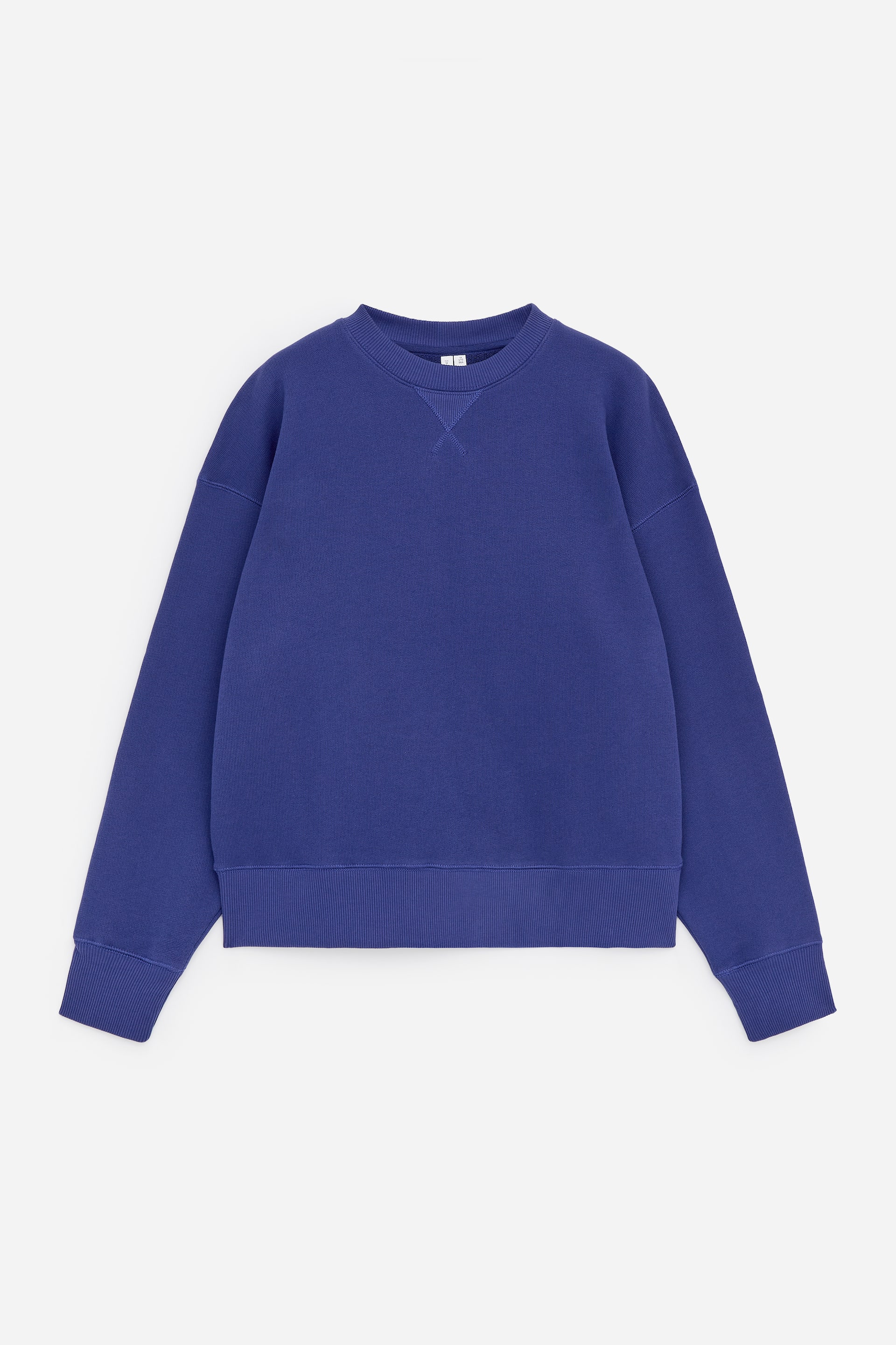 Visa större bild: En blå sweatshirt visas framifrån, med en avslappnad passform och nedhasade axlar. Den är designad med en ribbad rund hals, en V-söm detalj under kragen, samt ribbade muddar och fåll.